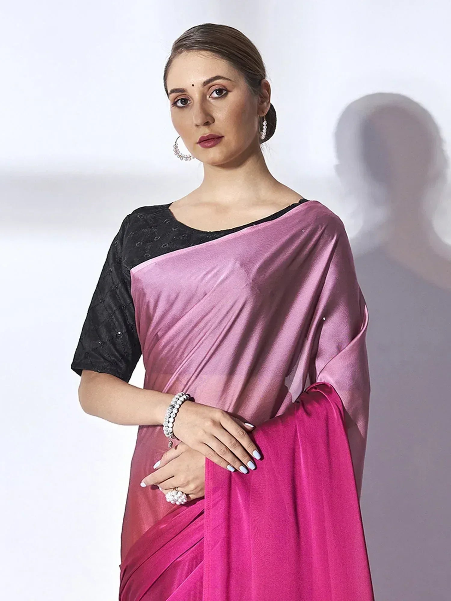 Woman in pink satin saree with black blouse, ethnic Indian wear for festive occasions