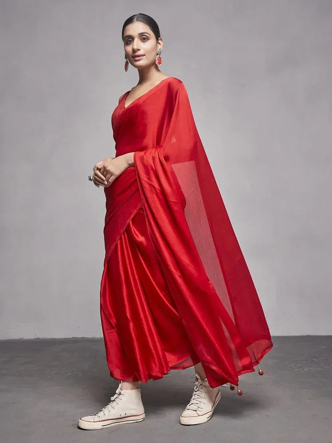 Red satin saree with sheer pallu, paired with white sneakers for modern ethnic look