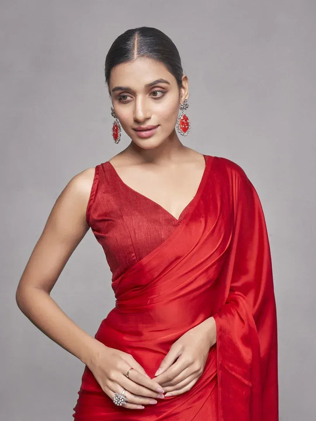 Woman in elegant red satin saree with matching earrings, perfect for Indian ethnic occasions