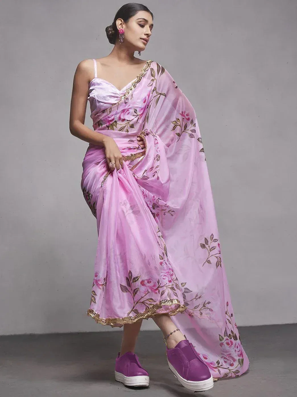 Pink floral saree with gold trim, styled with modern purple sneakers for ethnic fusion look