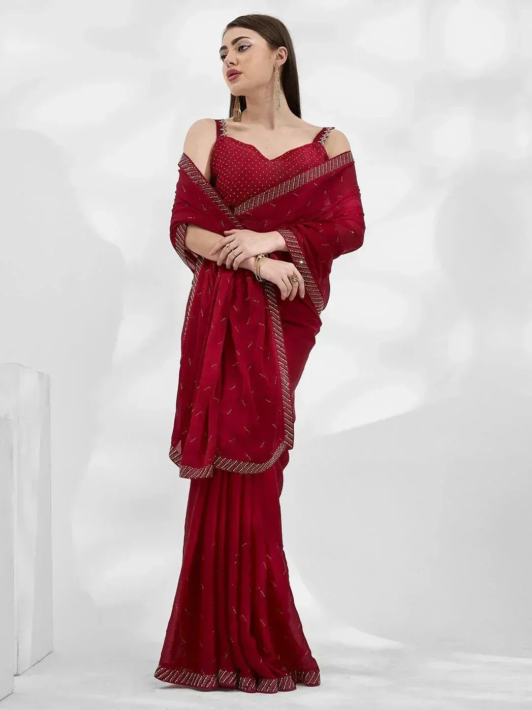 Red designer saree with gold embellishments and cold shoulder blouse, ethnic Indian wear