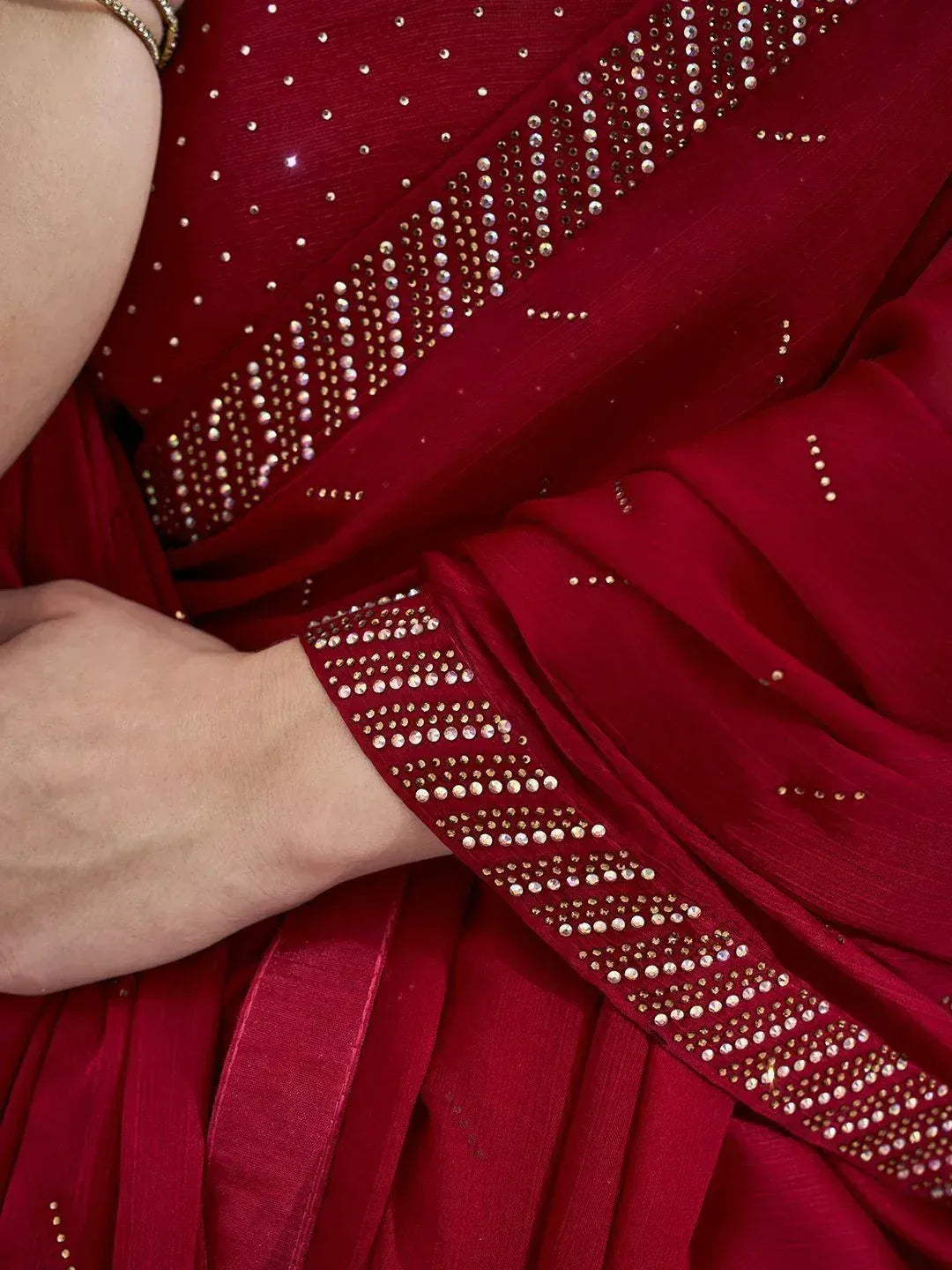 Rich maroon saree with intricate crystal embellishments on border and pallu, perfect for ethnic occasions
