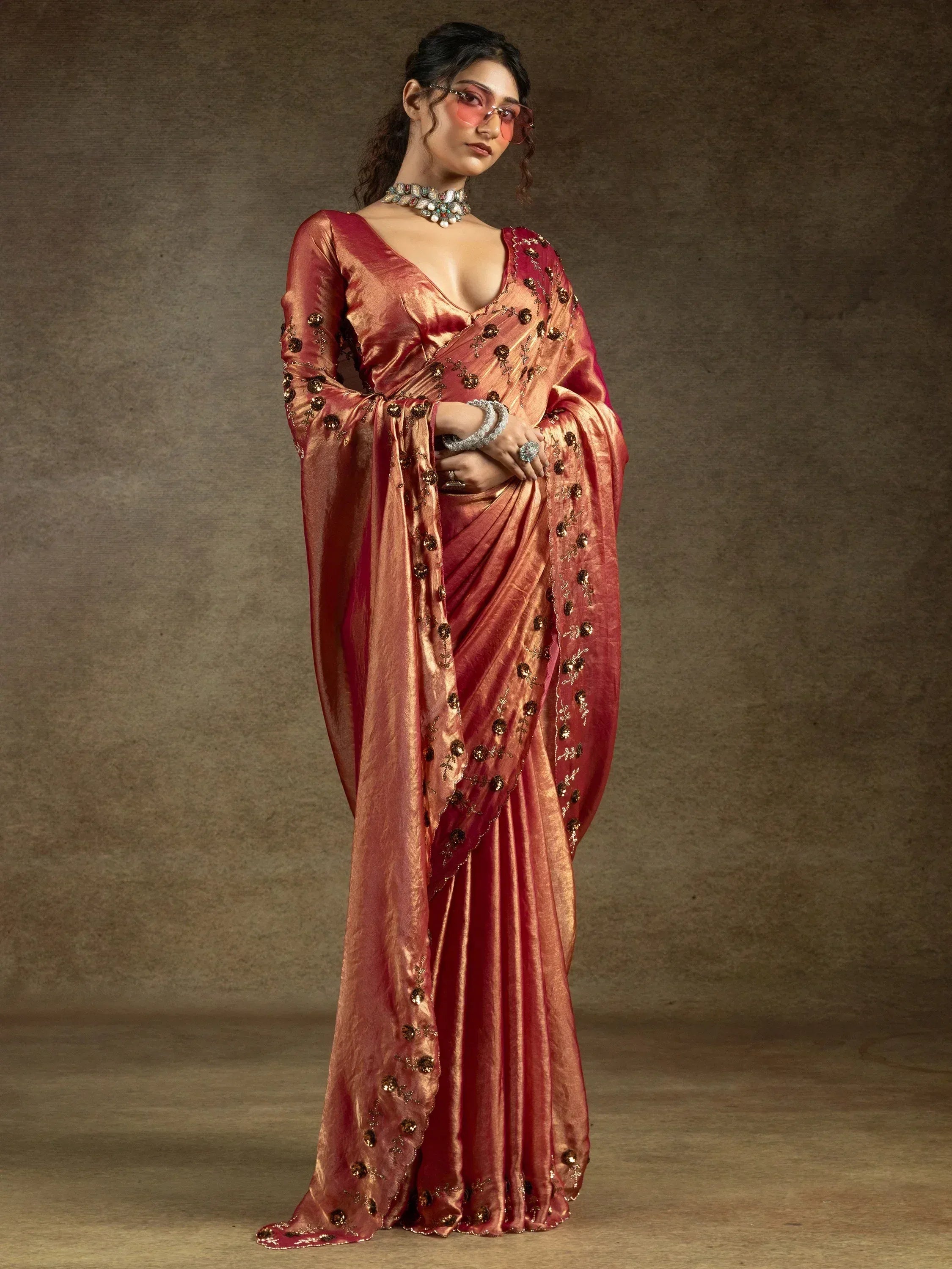Elegant maroon saree with gold embroidery, paired with statement jewelry for ethnic wear
