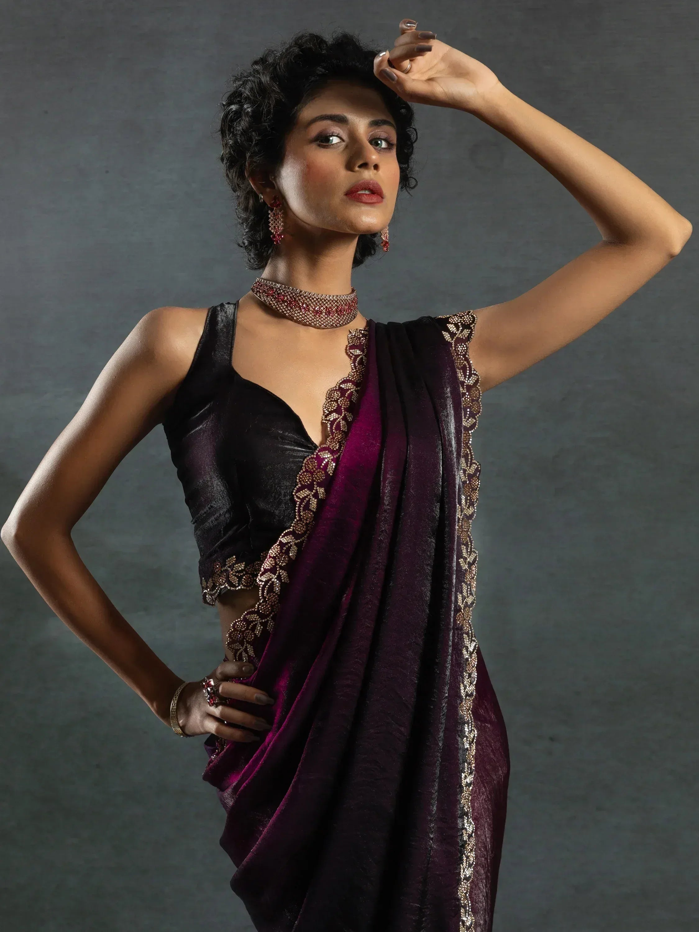 Elegant woman in purple velvet saree with gold embroidery and matching jewelry