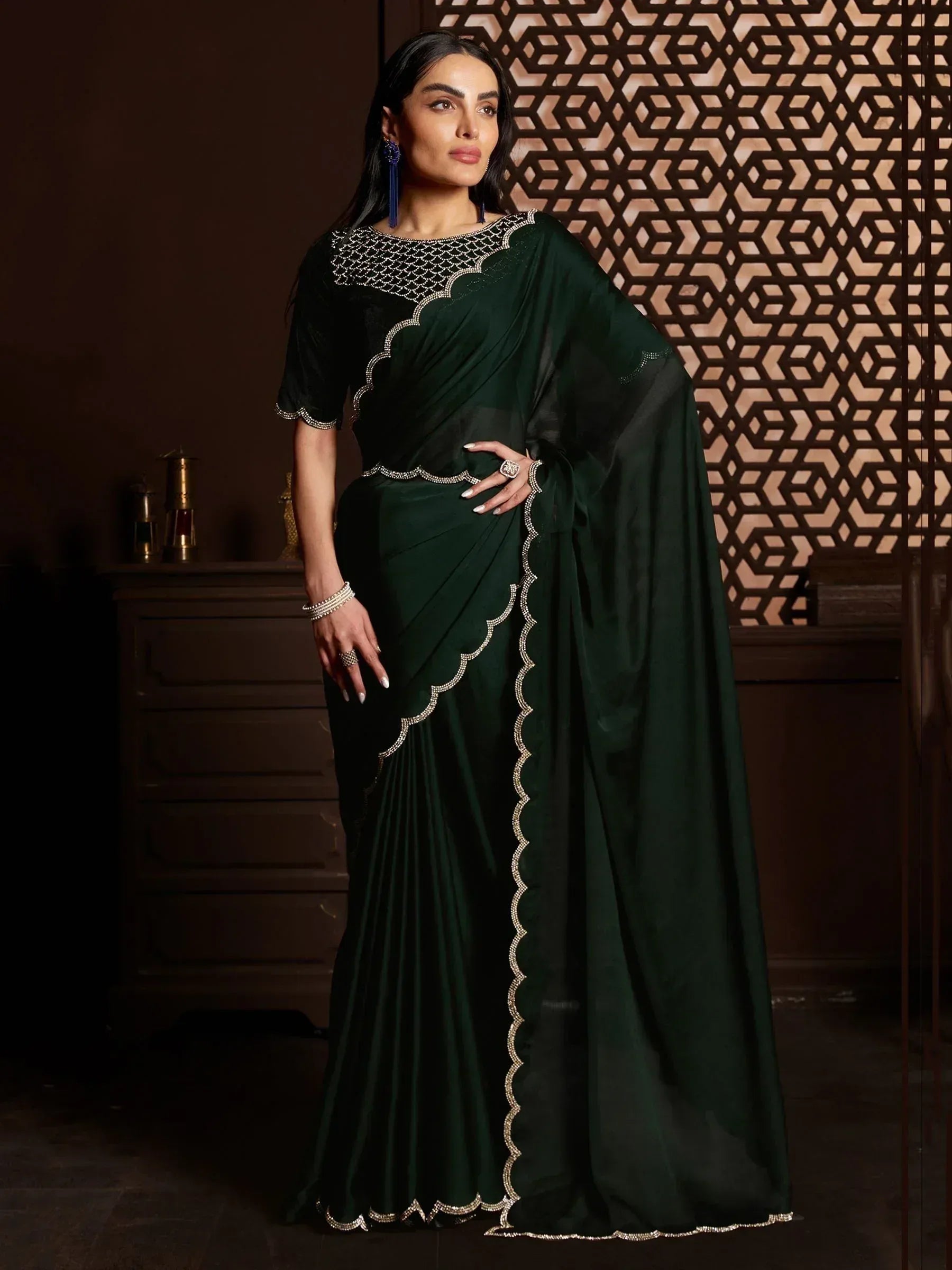 Elegant dark green saree with intricate silver embroidery and scalloped borders, perfect for Indian ethnic wear occasions.