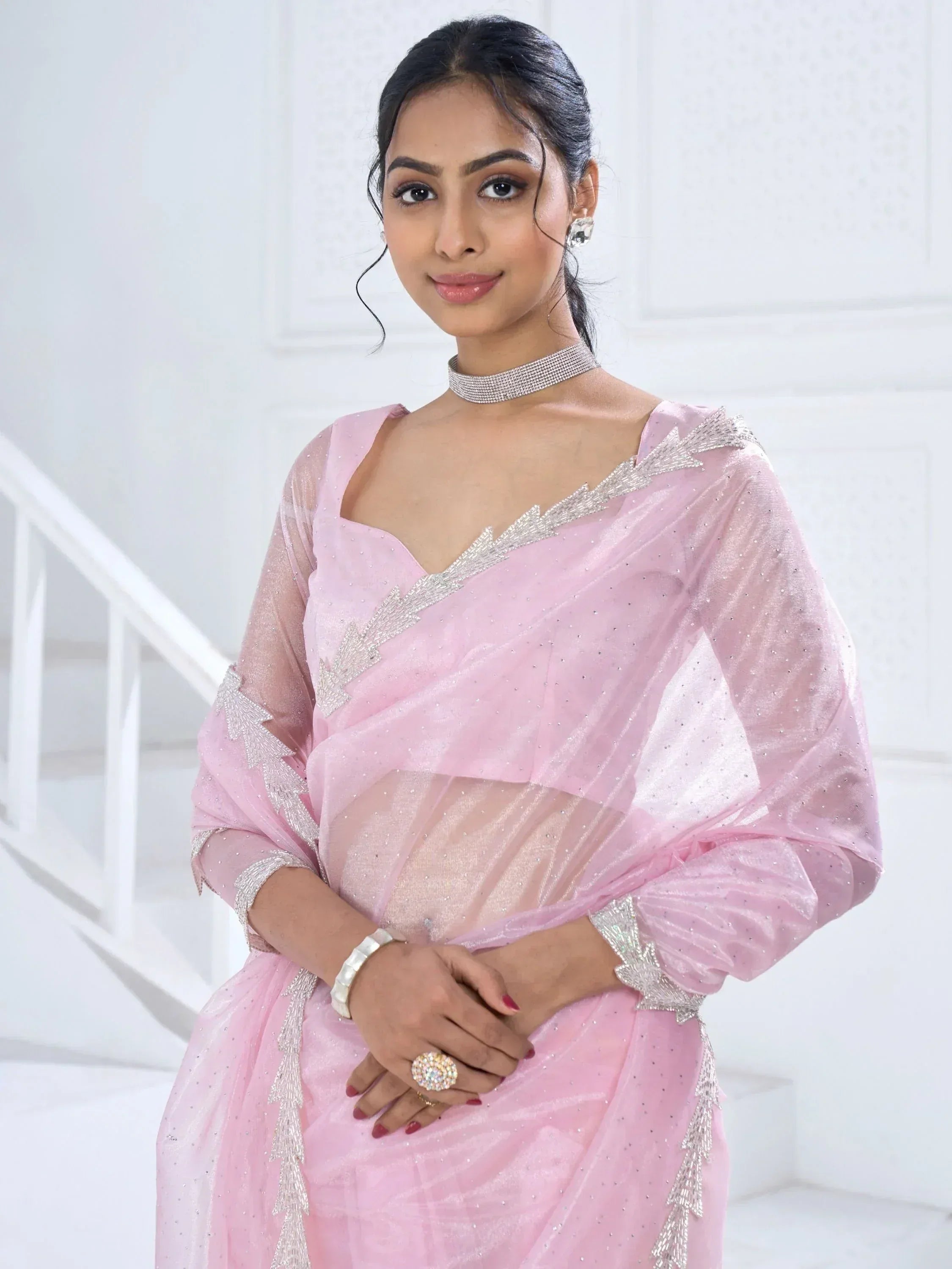 Pink ethnic saree with silver embellishments, perfect for Indian weddings and festive occasions.