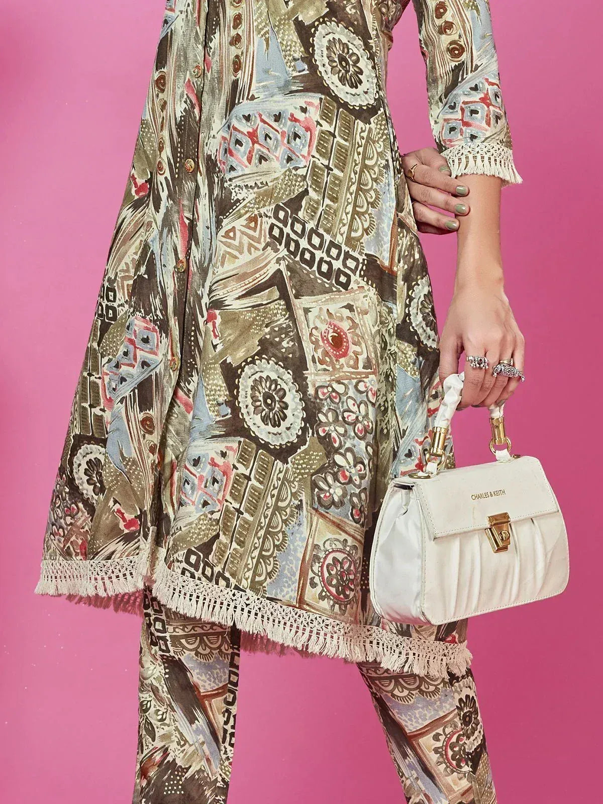Ethnic printed kurta with lace trim and matching pants, styled with white handbag