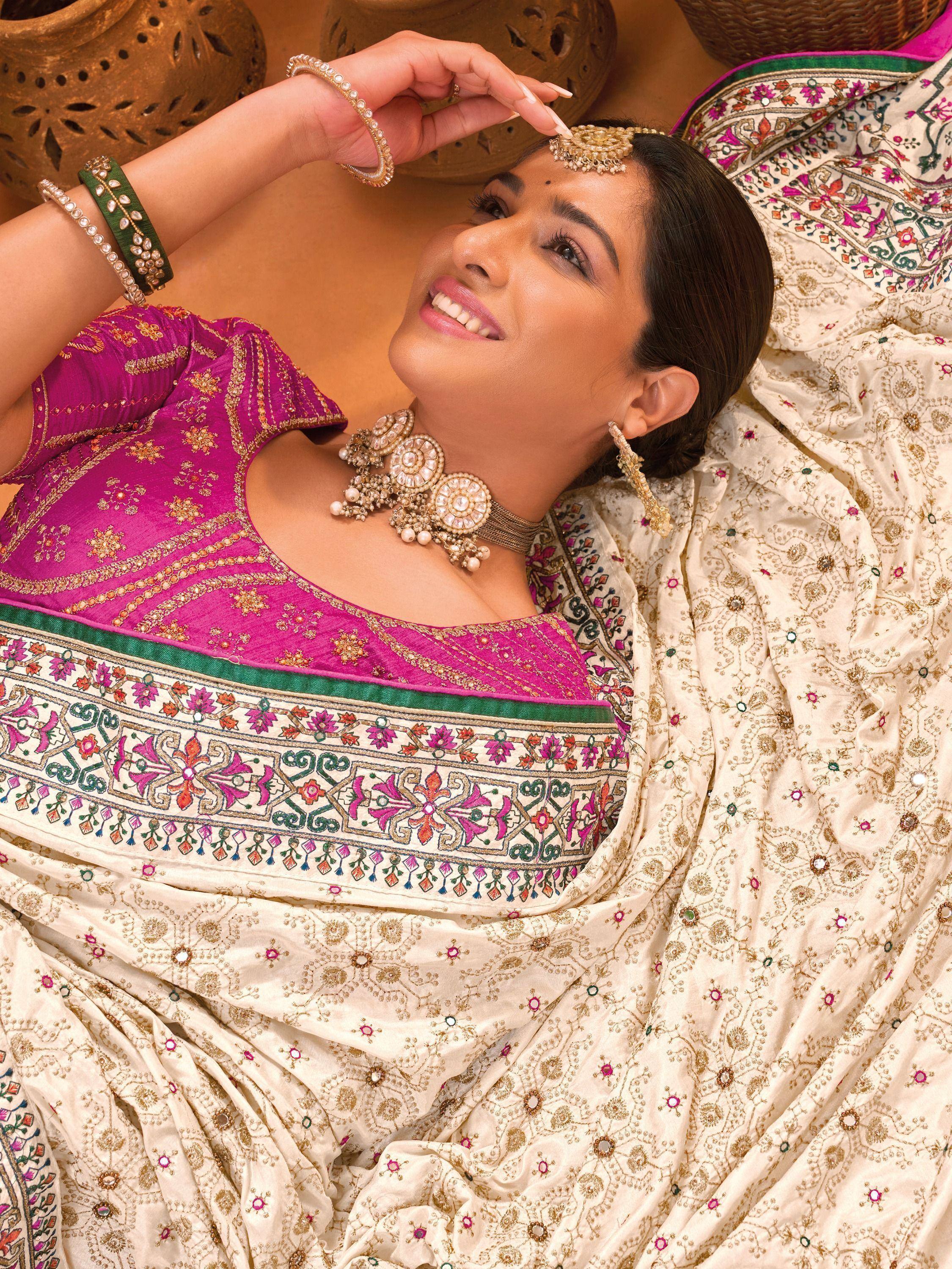 Woman in vibrant pink and cream embroidered Indian ethnic wear with traditional jewelry