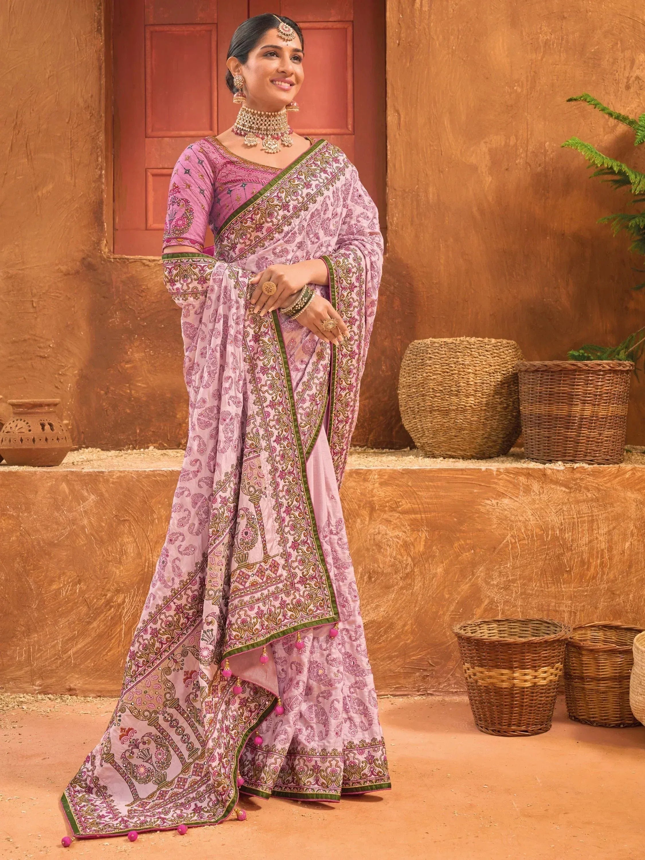 Woman in pink printed saree with green border, traditional Indian ethnic wear, perfect for festive occasions