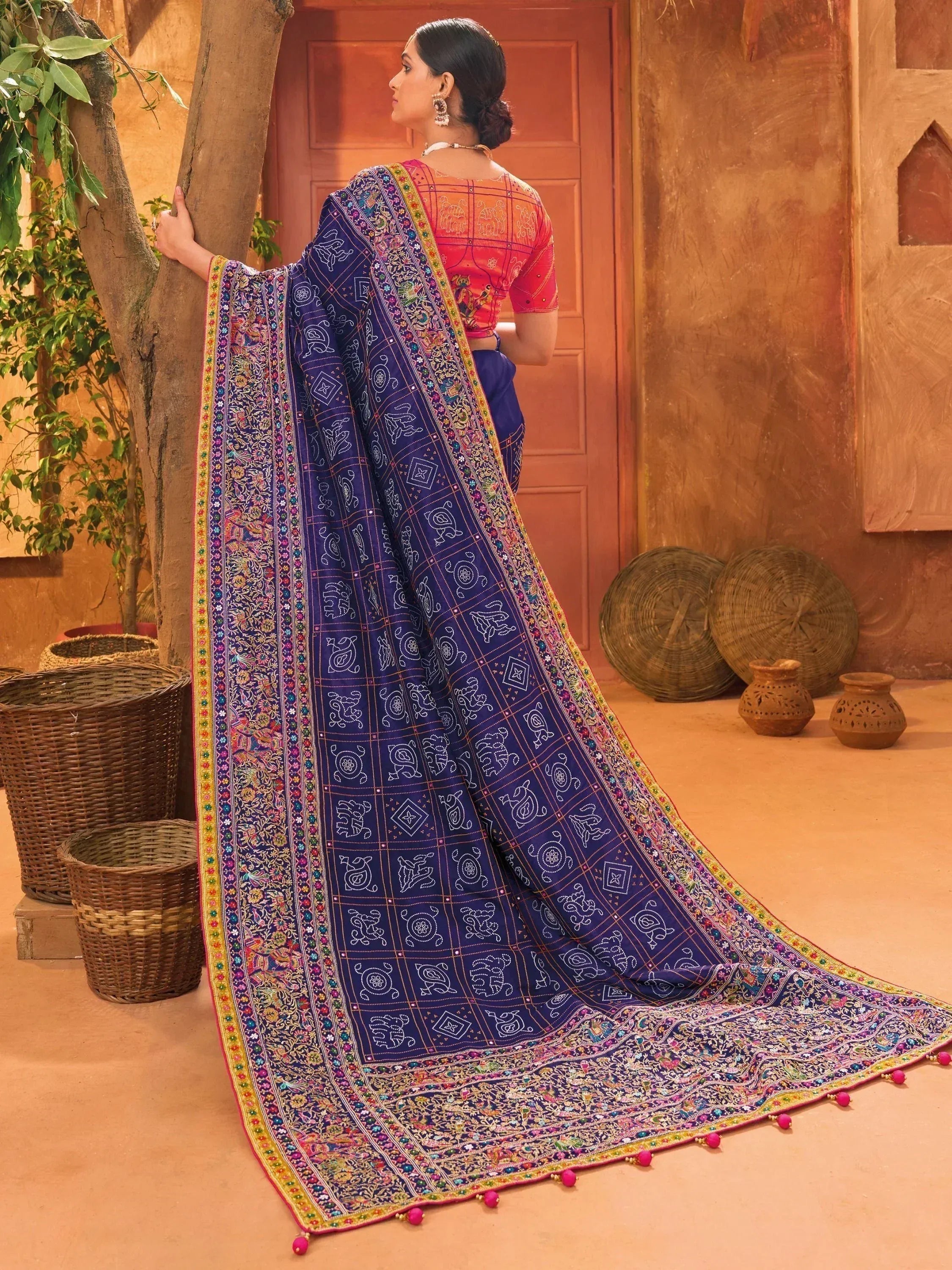 Woman in blue embroidered saree with elephant motifs, pink blouse, traditional Indian ethnic wear