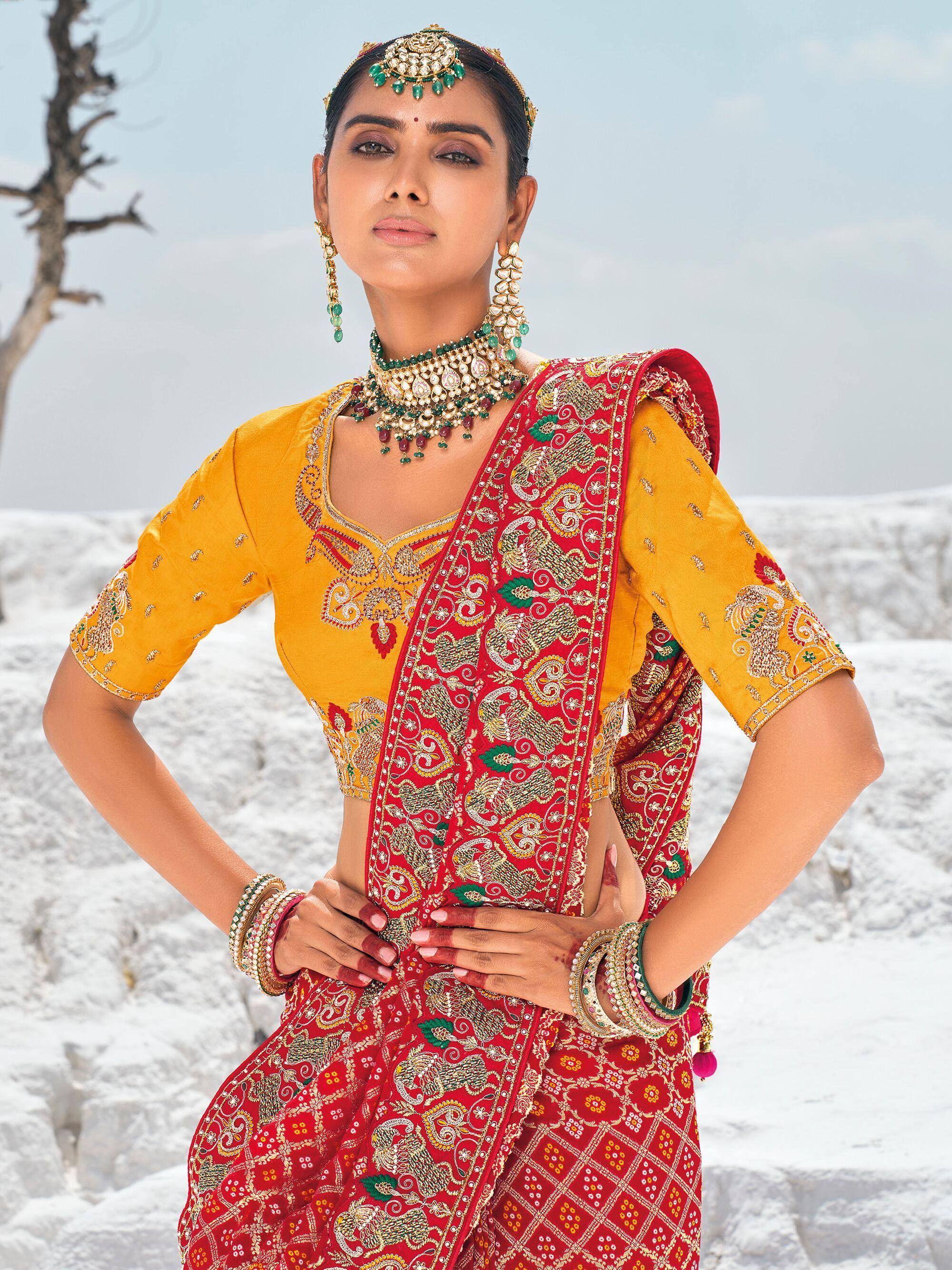 Woman in red and yellow embroidered lehenga choli with traditional jewelry, perfect for Indian ethnic wear.