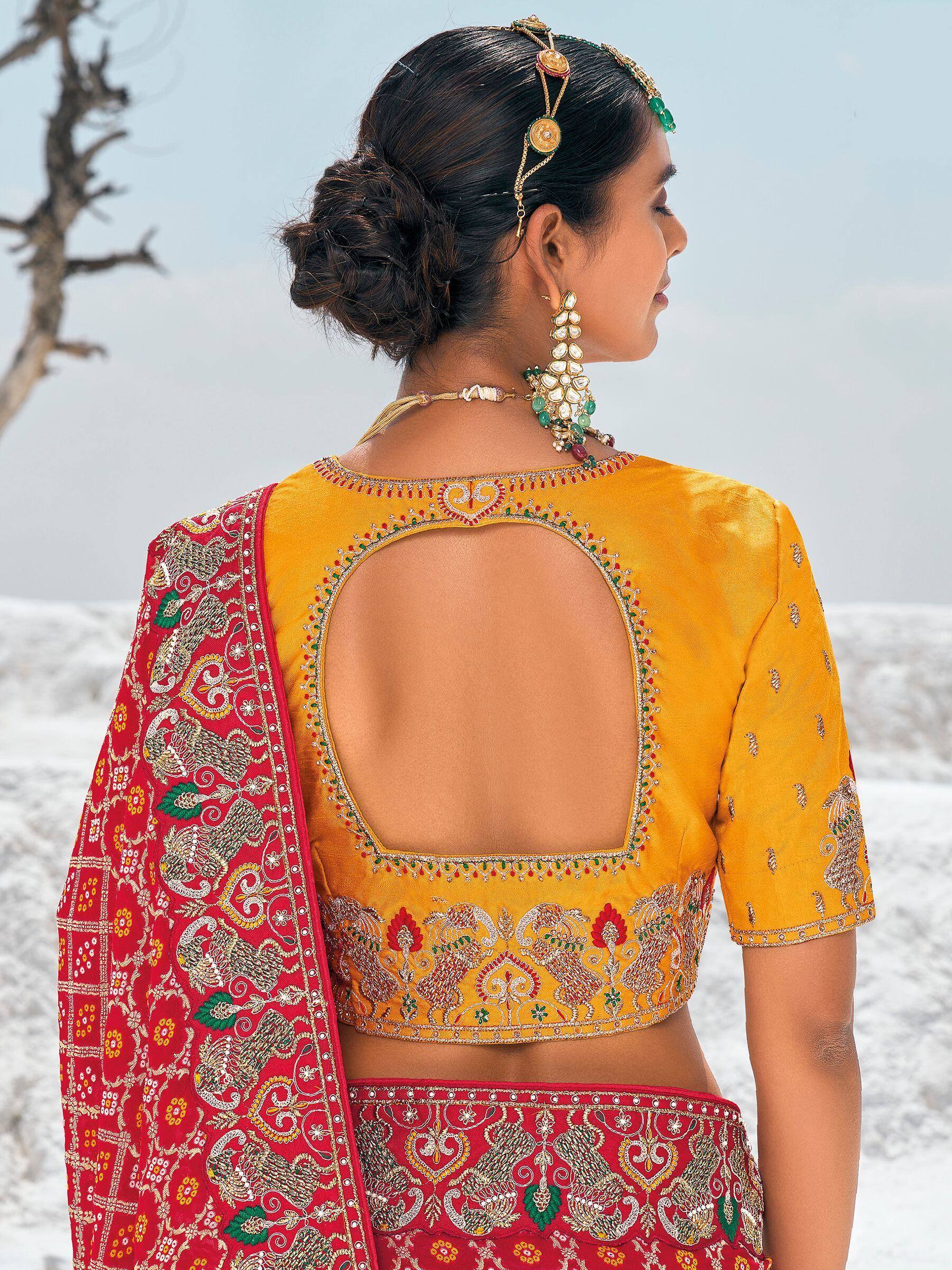 Yellow embroidered blouse with back cutout paired with red lehenga, traditional Indian ethnic wear