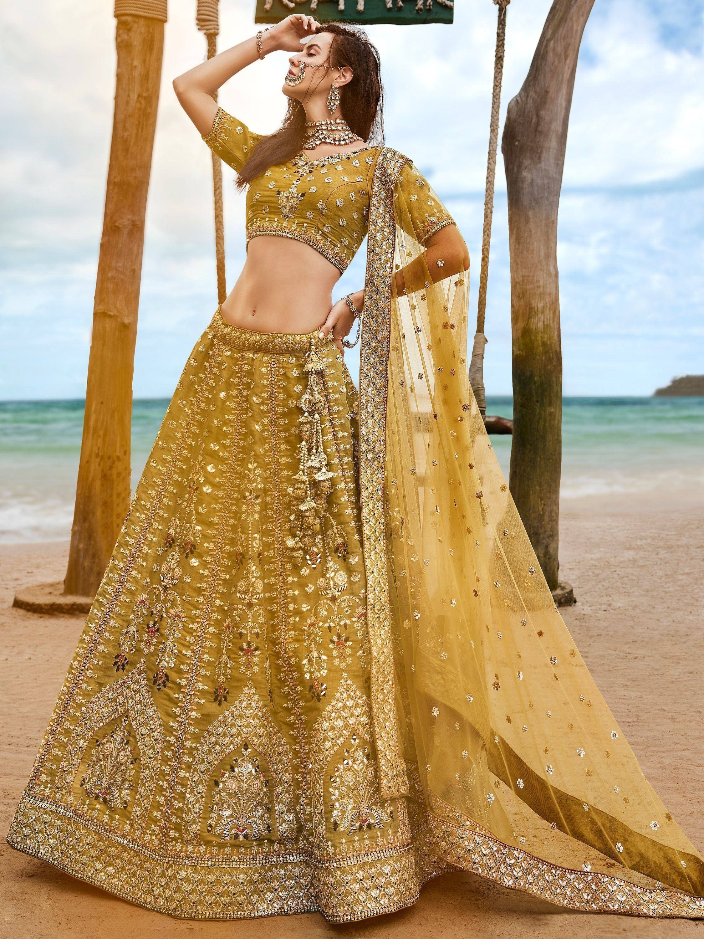 Mustard yellow designer lehenga choli with heavy embroidery, perfect for Indian weddings or festive occasions.