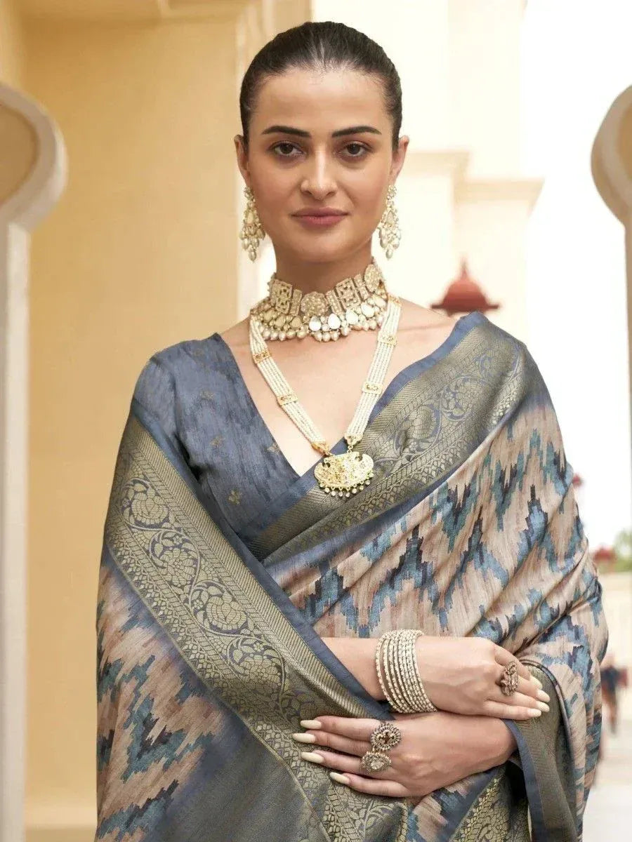 Elegant woman in blue and beige patterned saree with gold jewelry, perfect for Indian ethnic occasions