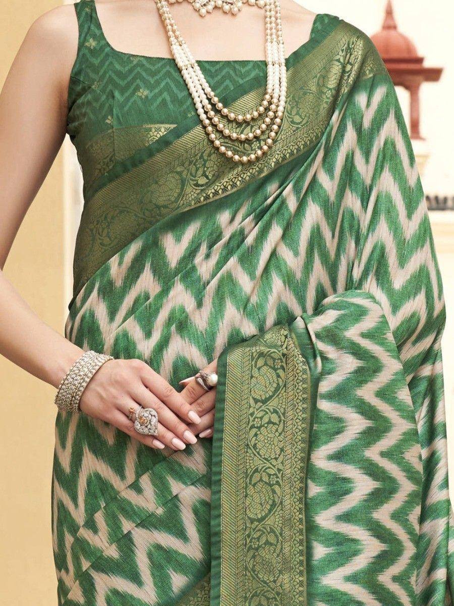 Green and cream ikat saree with gold border, paired with pearl jewelry and ethnic blouse