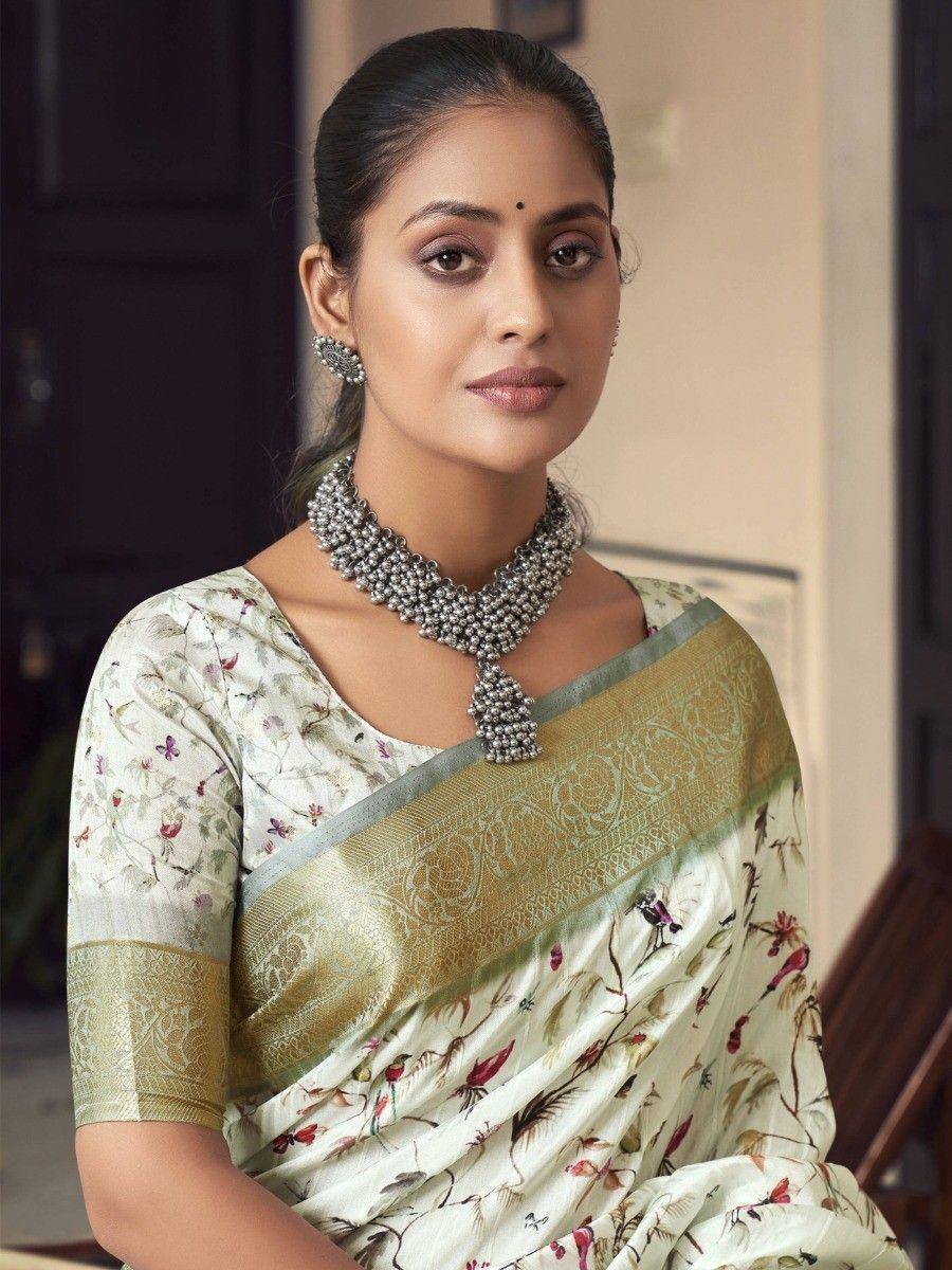 Woman in floral print saree with gold border, ethnic Indian wear, traditional jewelry