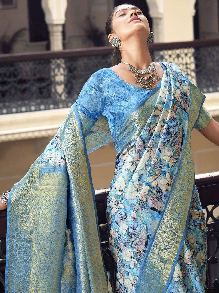 Blue floral print saree with gold border, styled with ethnic jewelry for traditional Indian wear