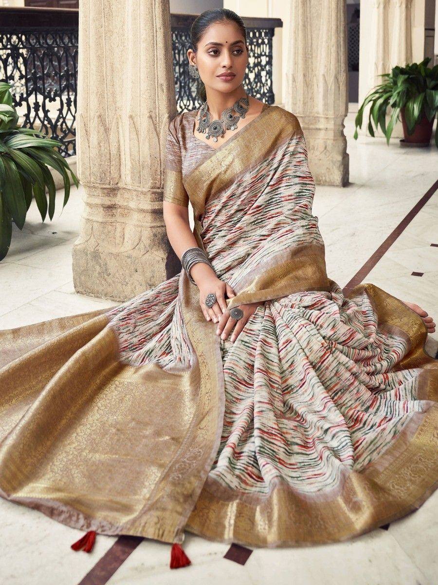 Woman in elegant Indian saree with gold border and multicolor stripes, styled with traditional jewelry