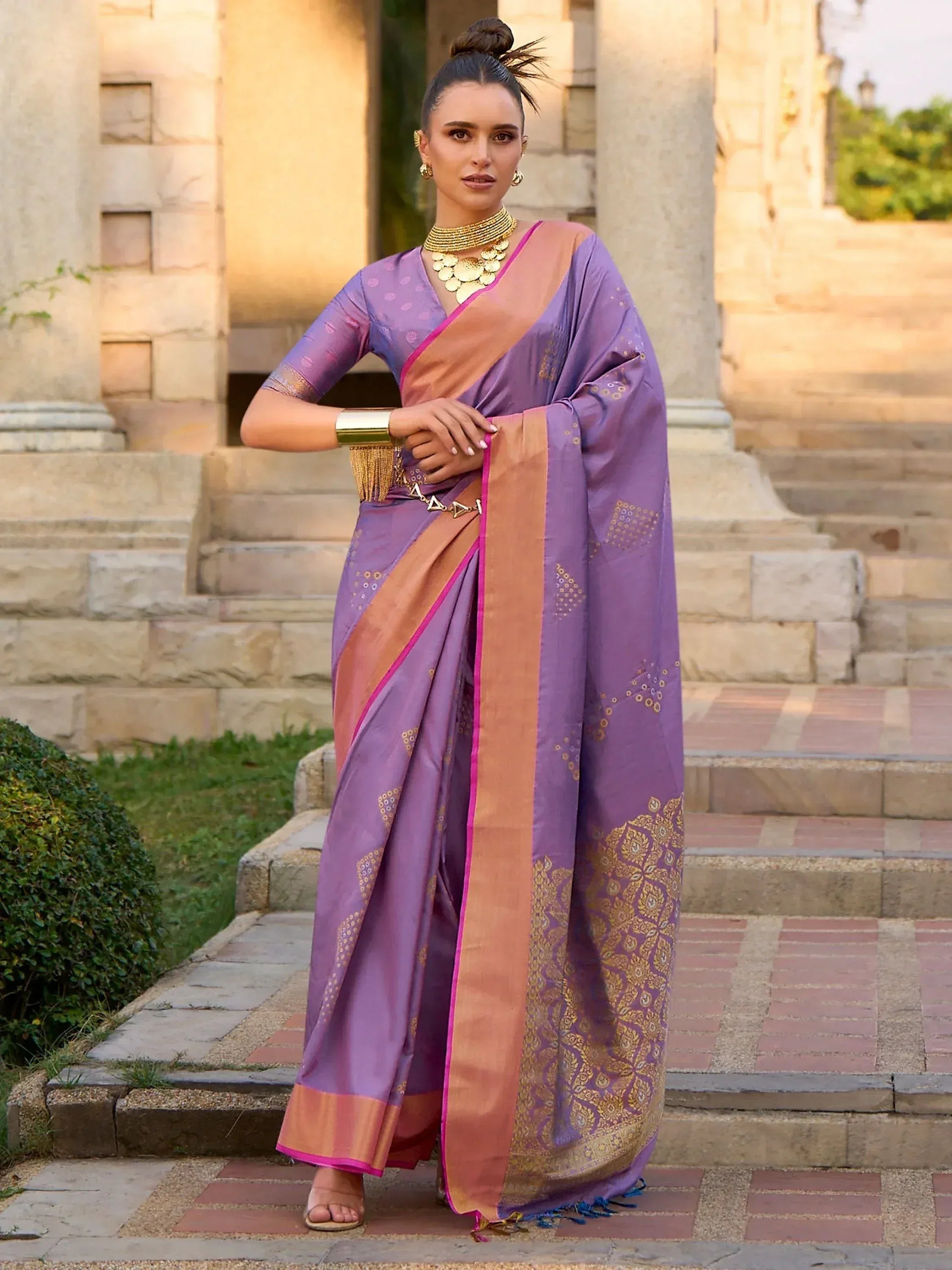 Purple designer saree with gold embroidery and pink border, styled with traditional jewelry for ethnic occasions