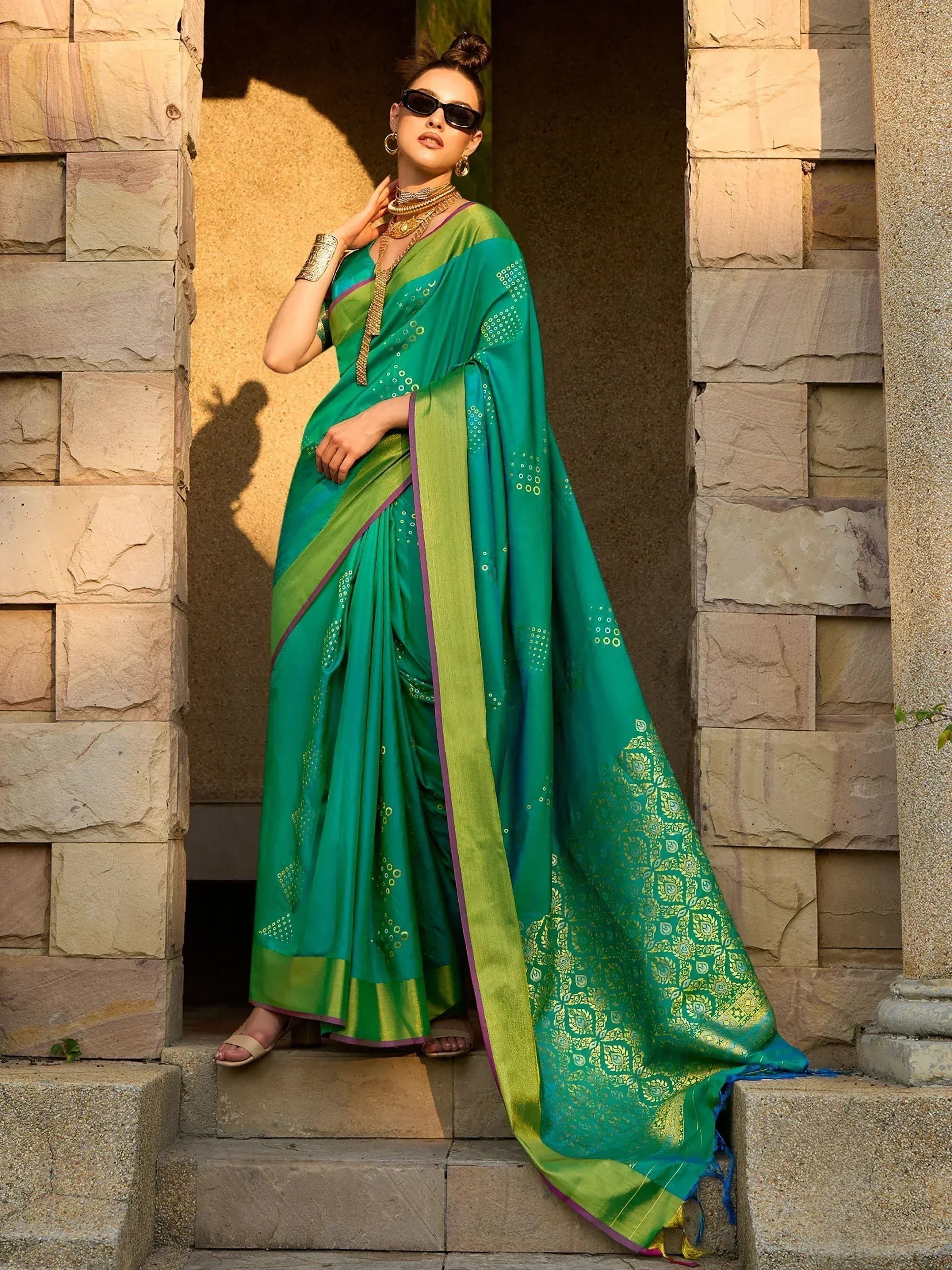Elegant green saree with gold embroidery and border, styled with statement jewelry for Indian ethnic wear