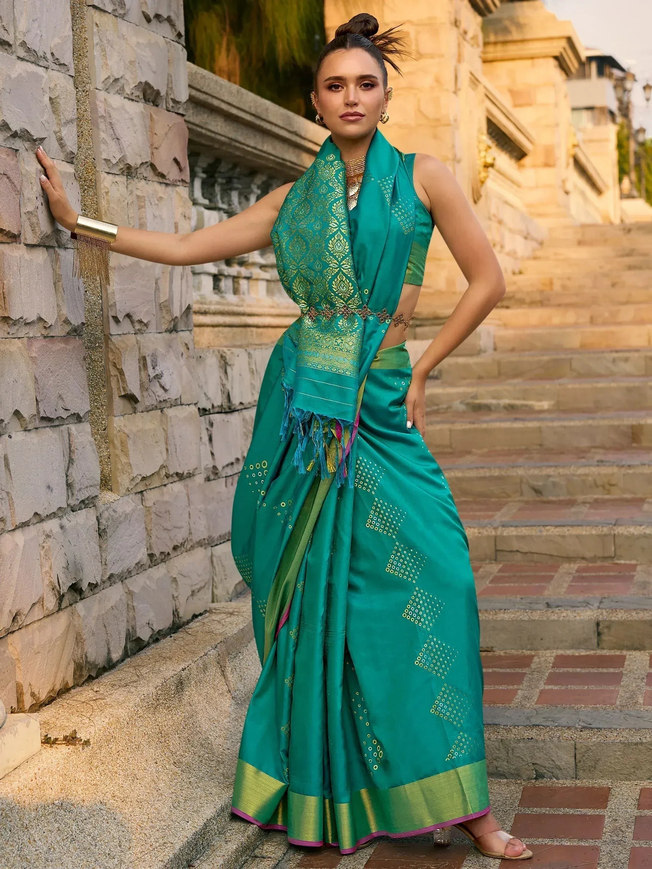 Teal green designer saree with gold embroidery and border, styled with matching blouse and jewelry