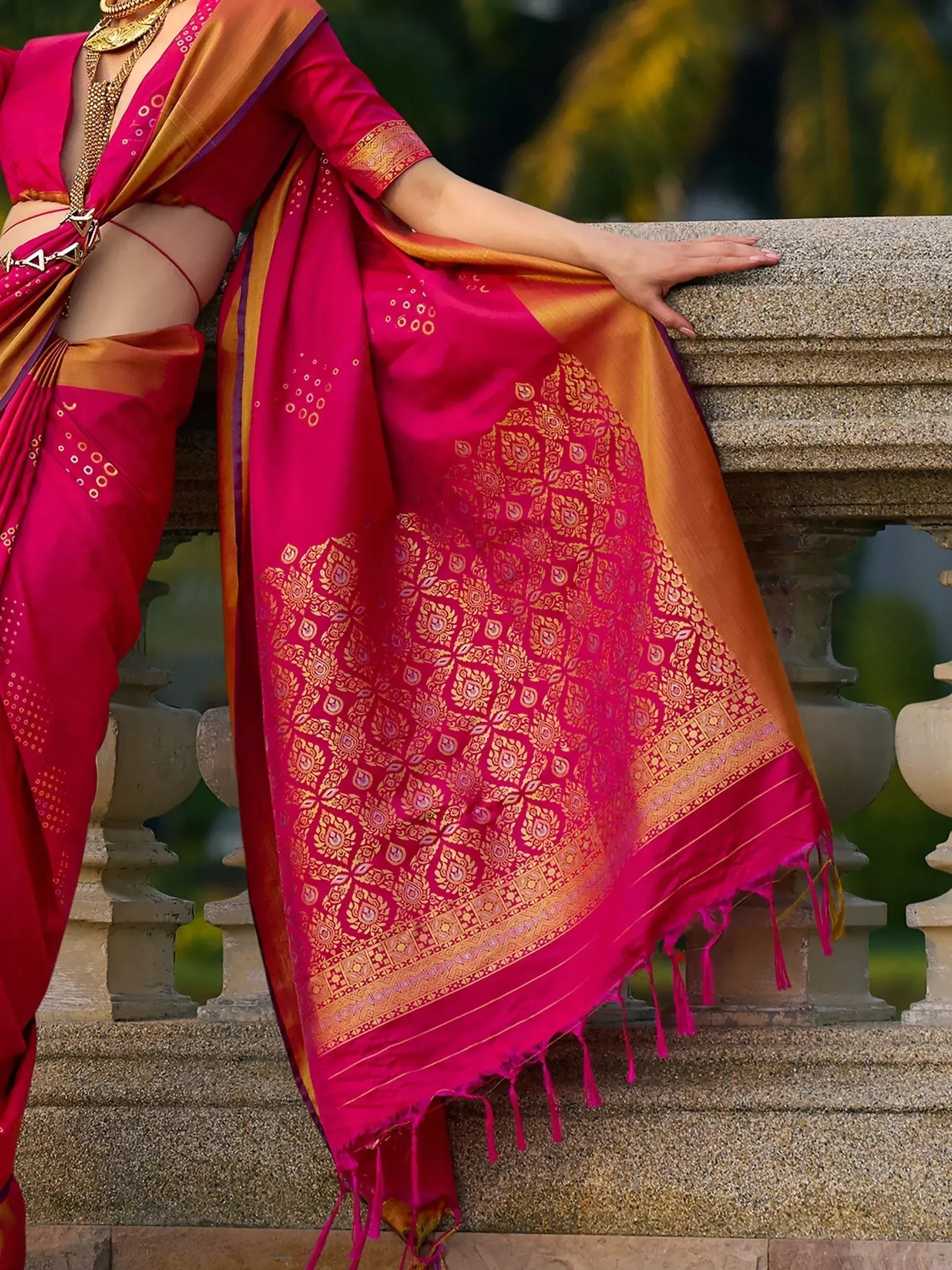 Vibrant pink and gold designer saree with intricate patterns, perfect for ethnic occasions.