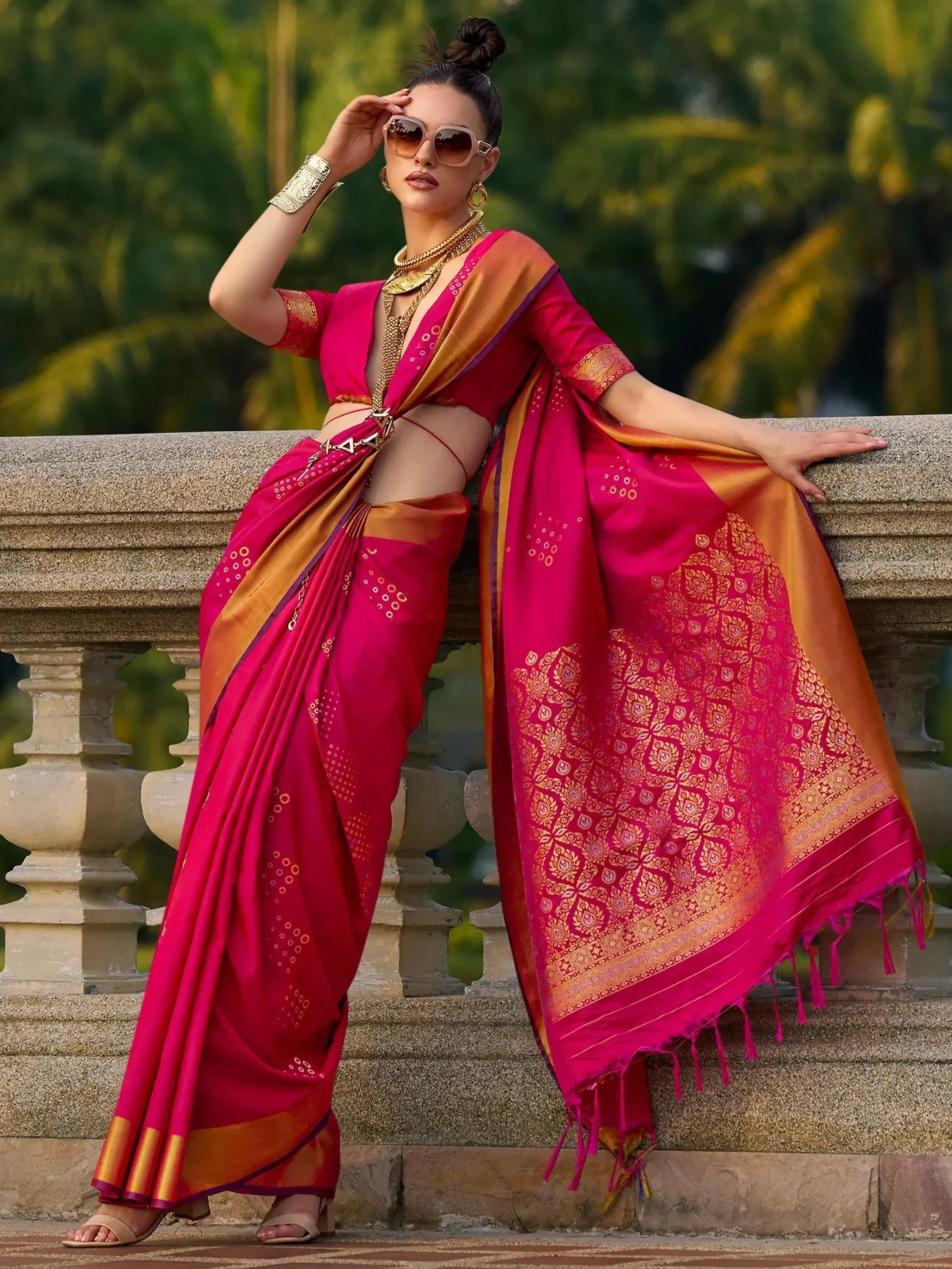 Vibrant pink and gold designer saree with intricate patterns, perfect for ethnic wear occasions.