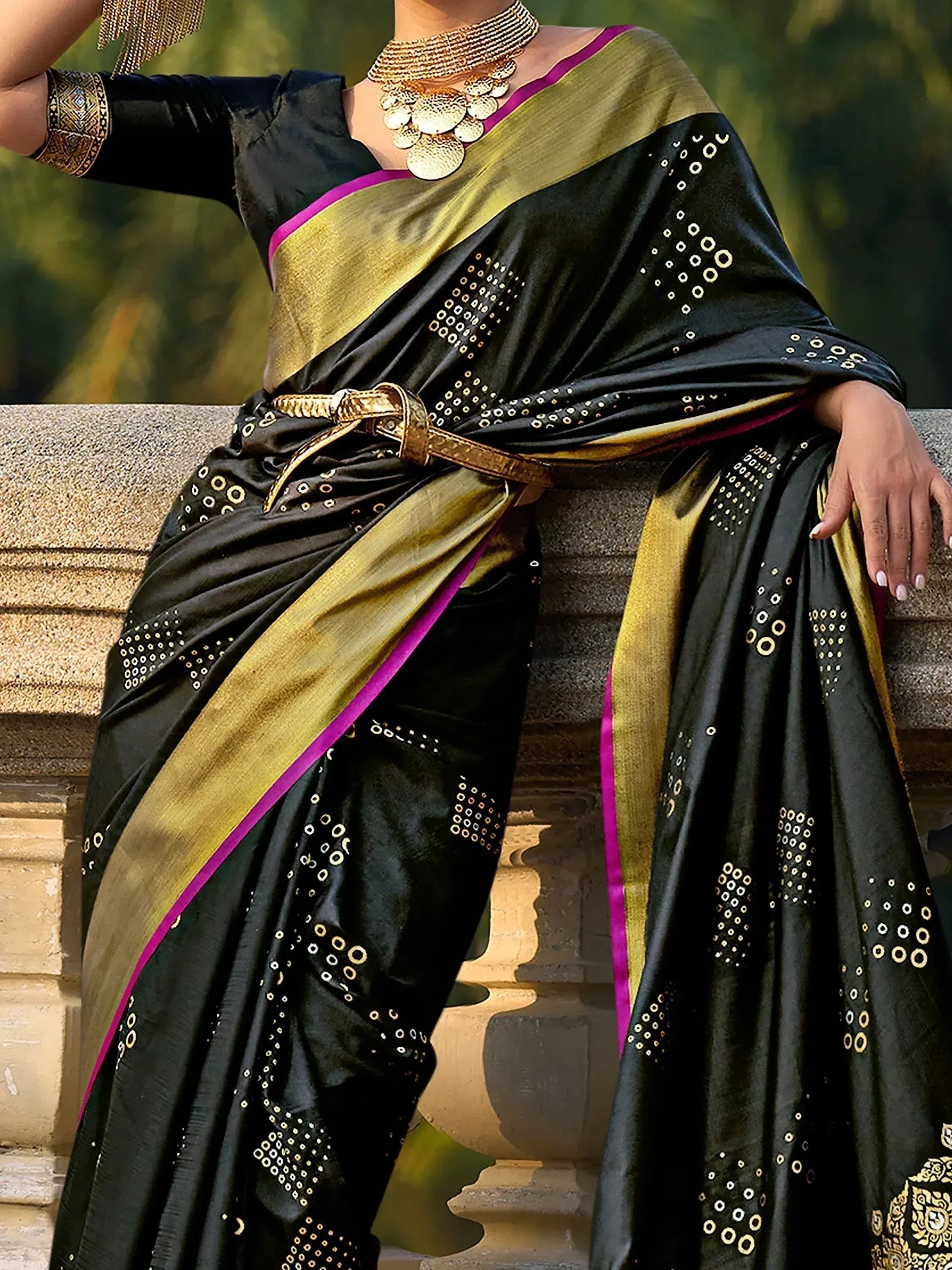 Black and gold ethnic saree with mirror work, purple border, and statement jewelry for festive occasions
