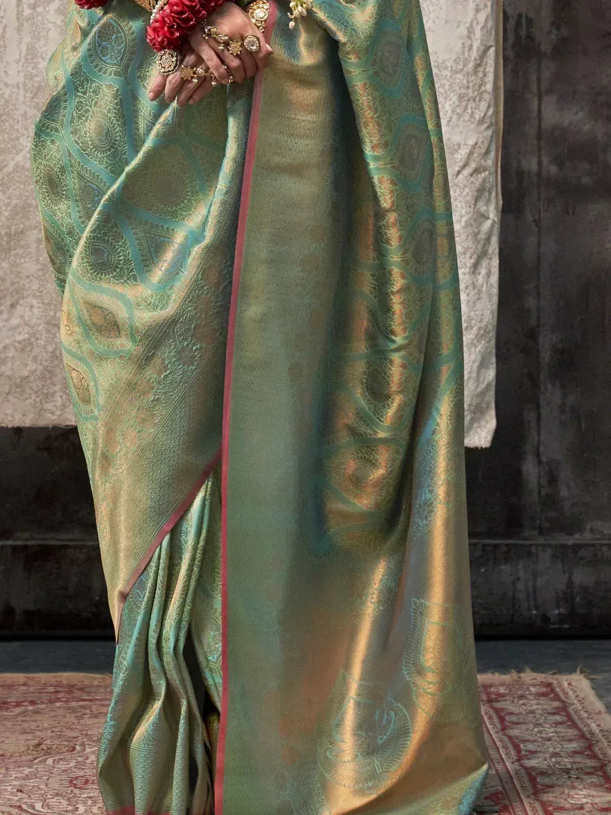 Elegant green and gold designer saree with intricate paisley weave, perfect for Indian ethnic occasions.
