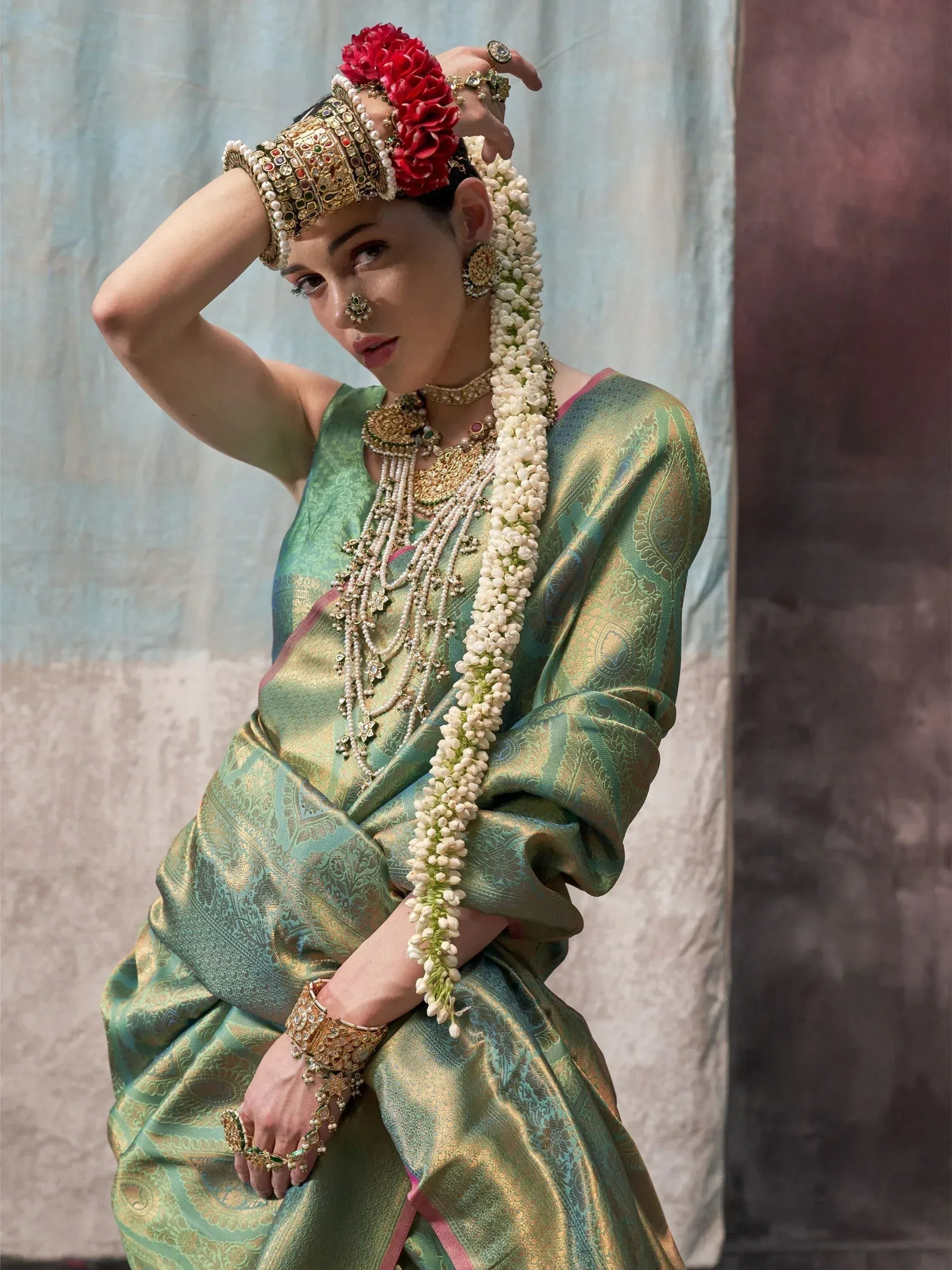 Woman in green gold saree with floral crown and temple jewelry, traditional Indian ethnic wear