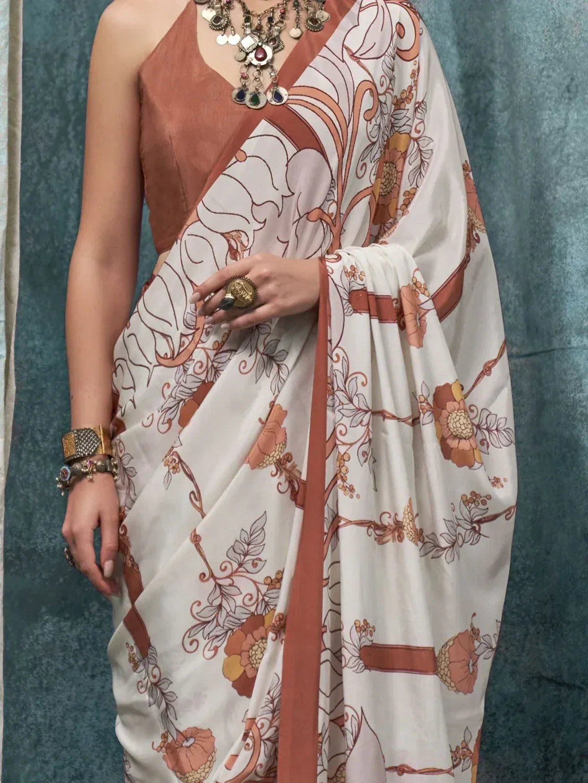 Elegant white saree with terracotta floral print, paired with matching blouse and statement jewelry for ethnic wear.