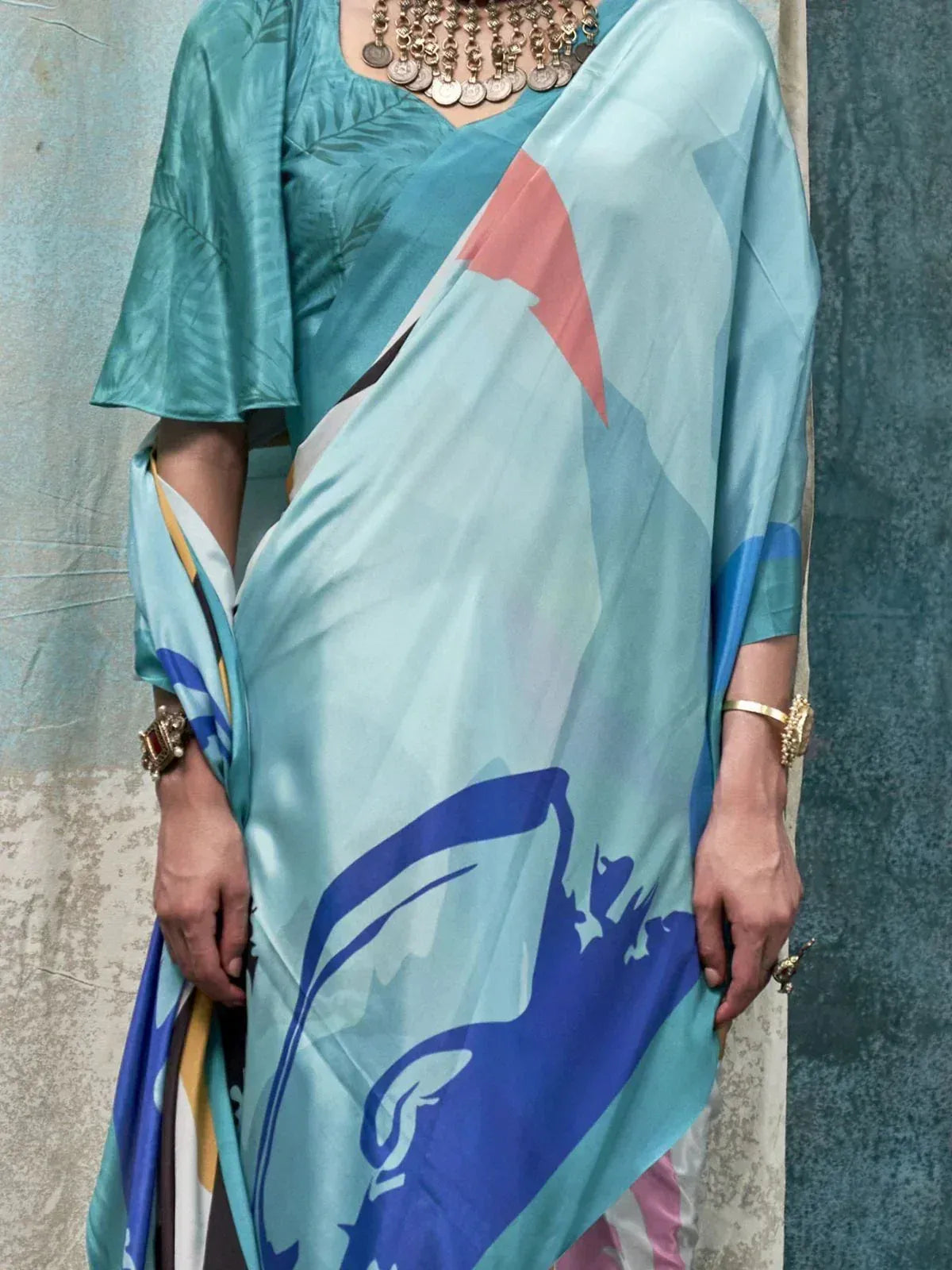 Stylish blue printed saree with geometric design, paired with matching blouse and ethnic jewelry