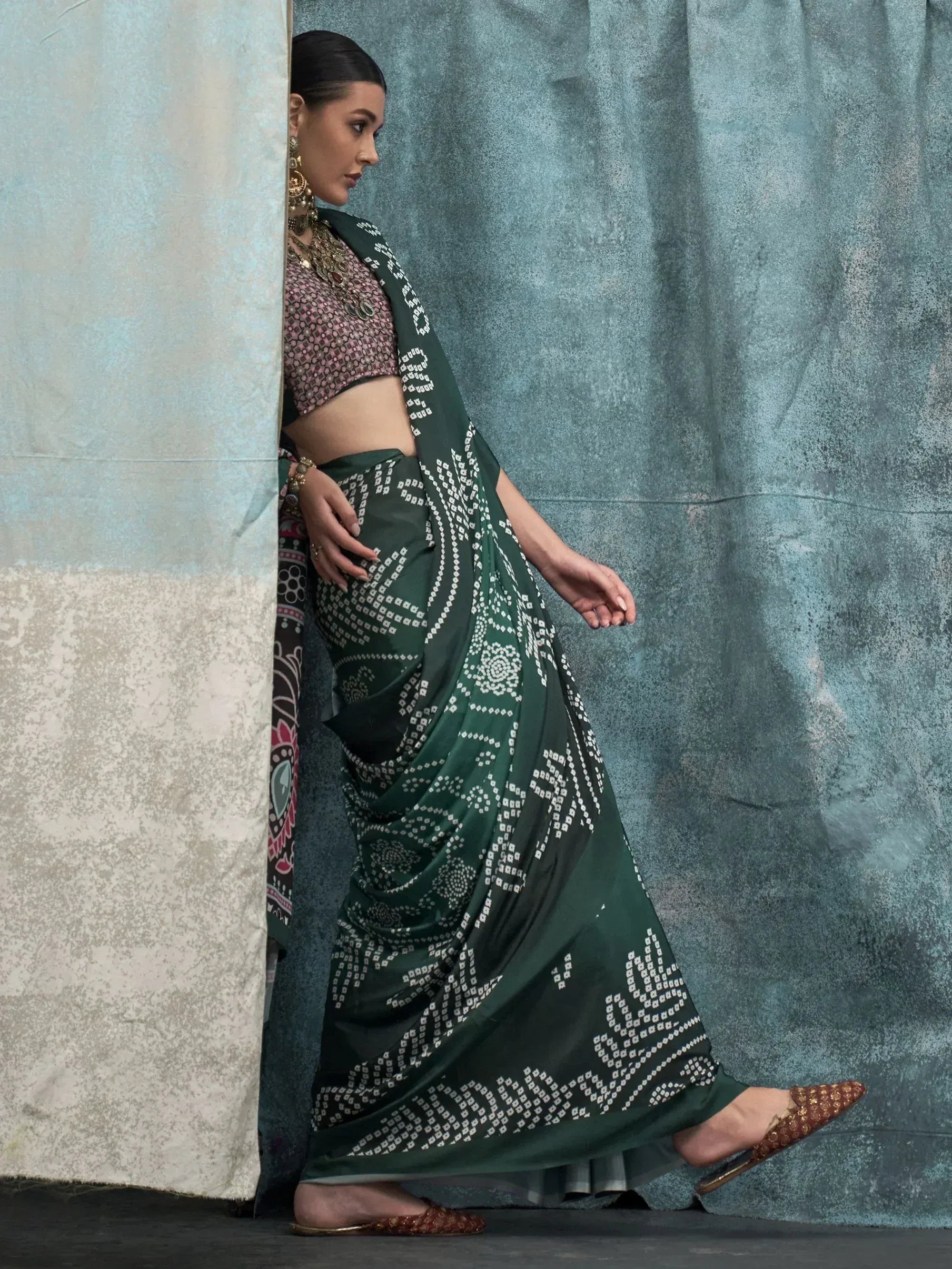 Woman in green printed saree with ethnic blouse and gold jewelry, stylish Indian ethnic wear