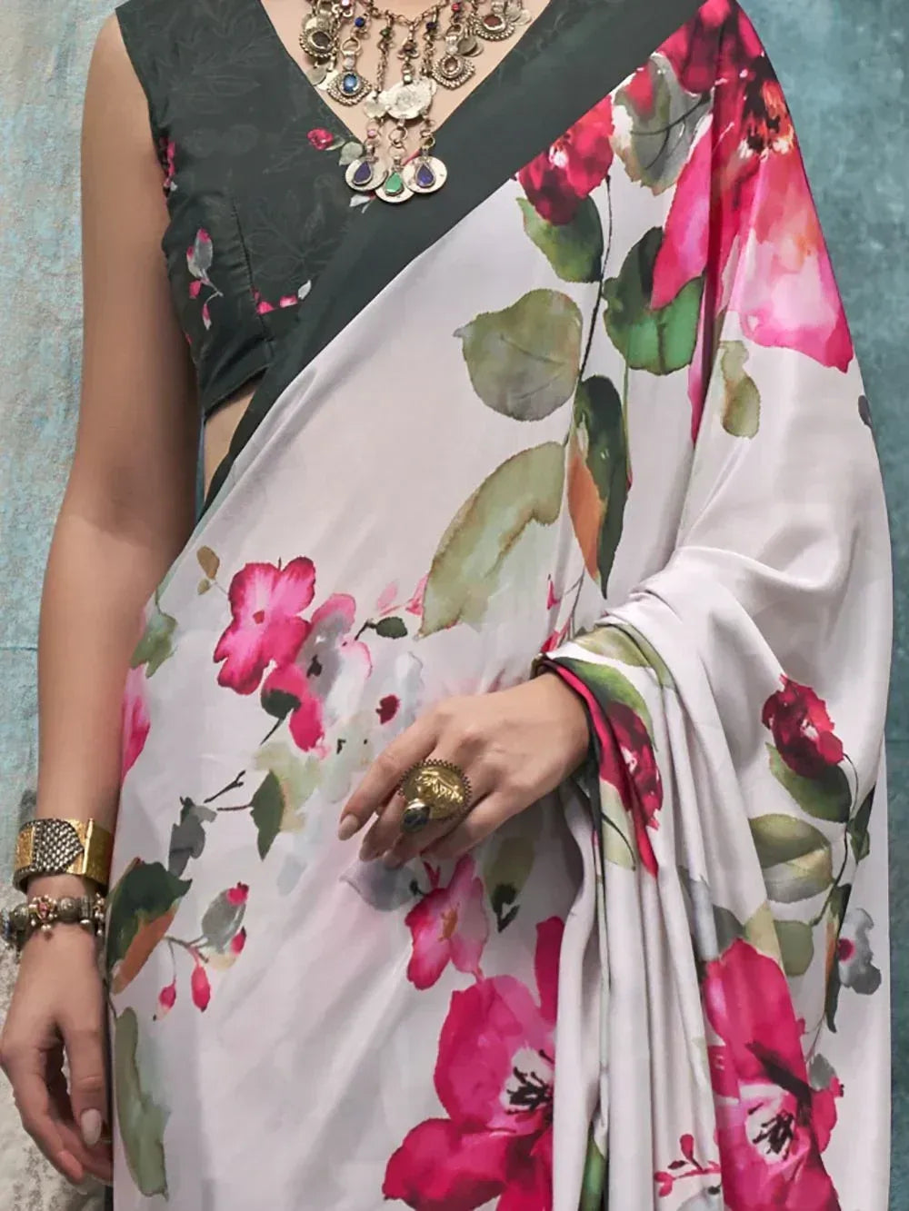 Floral print saree with pink blooms, green leaves, and dark blouse, styled with ethnic jewelry for Indian ethnic wear