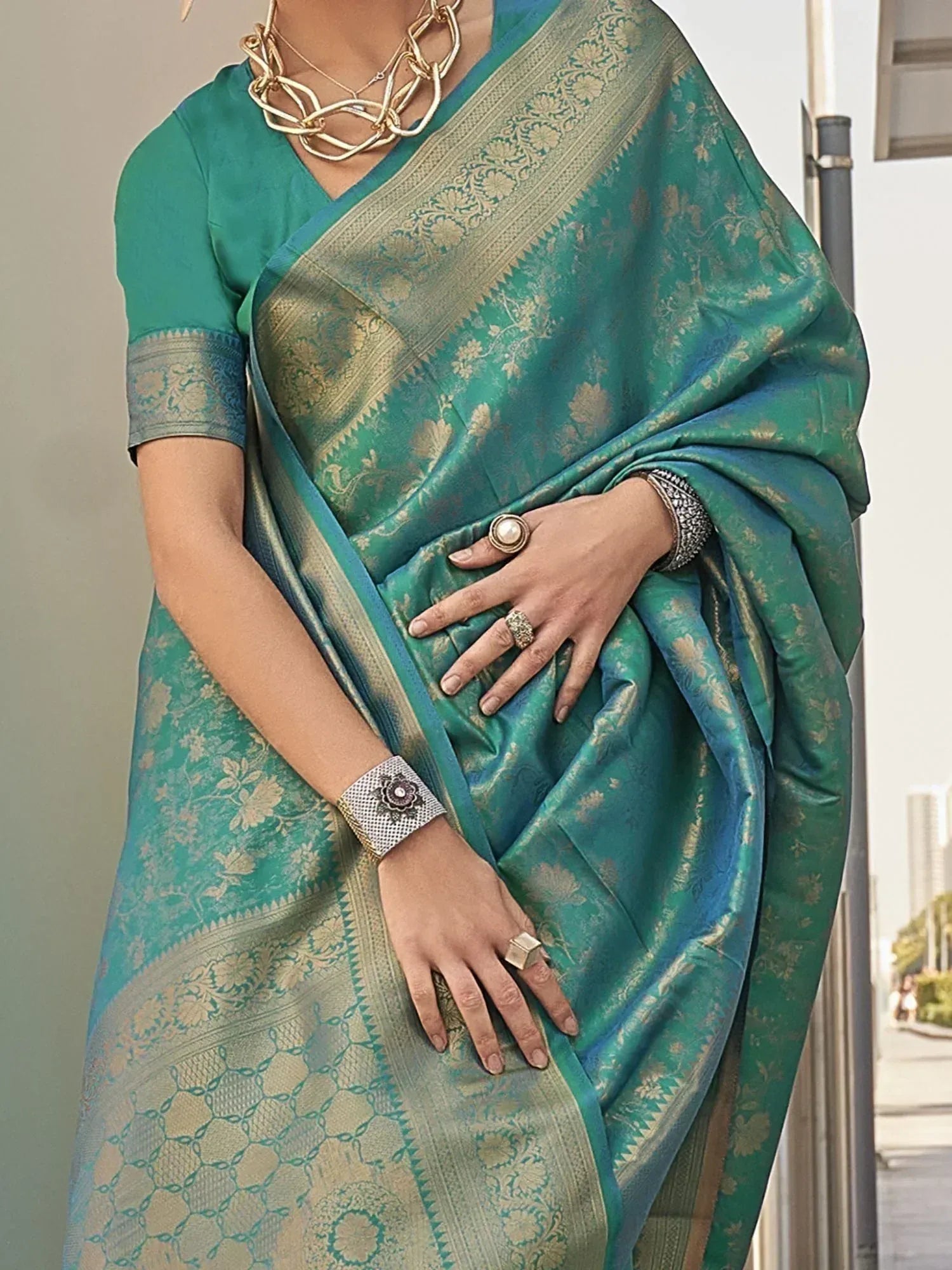 Teal green silk saree with gold floral zari work, perfect for Indian ethnic wear and festive occasions.