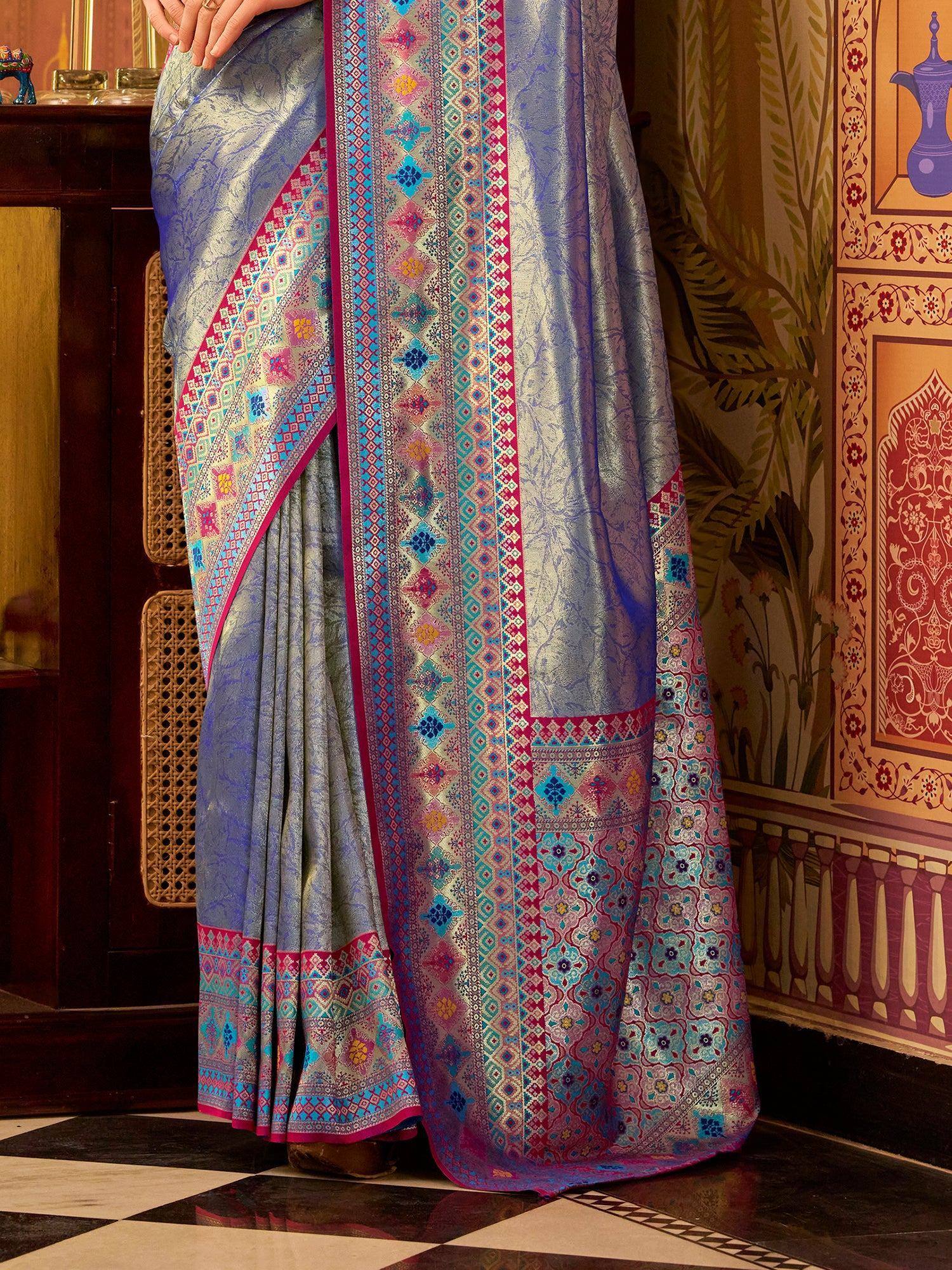 Elegant blue saree with vibrant geometric and floral border designs, perfect for ethnic occasions.