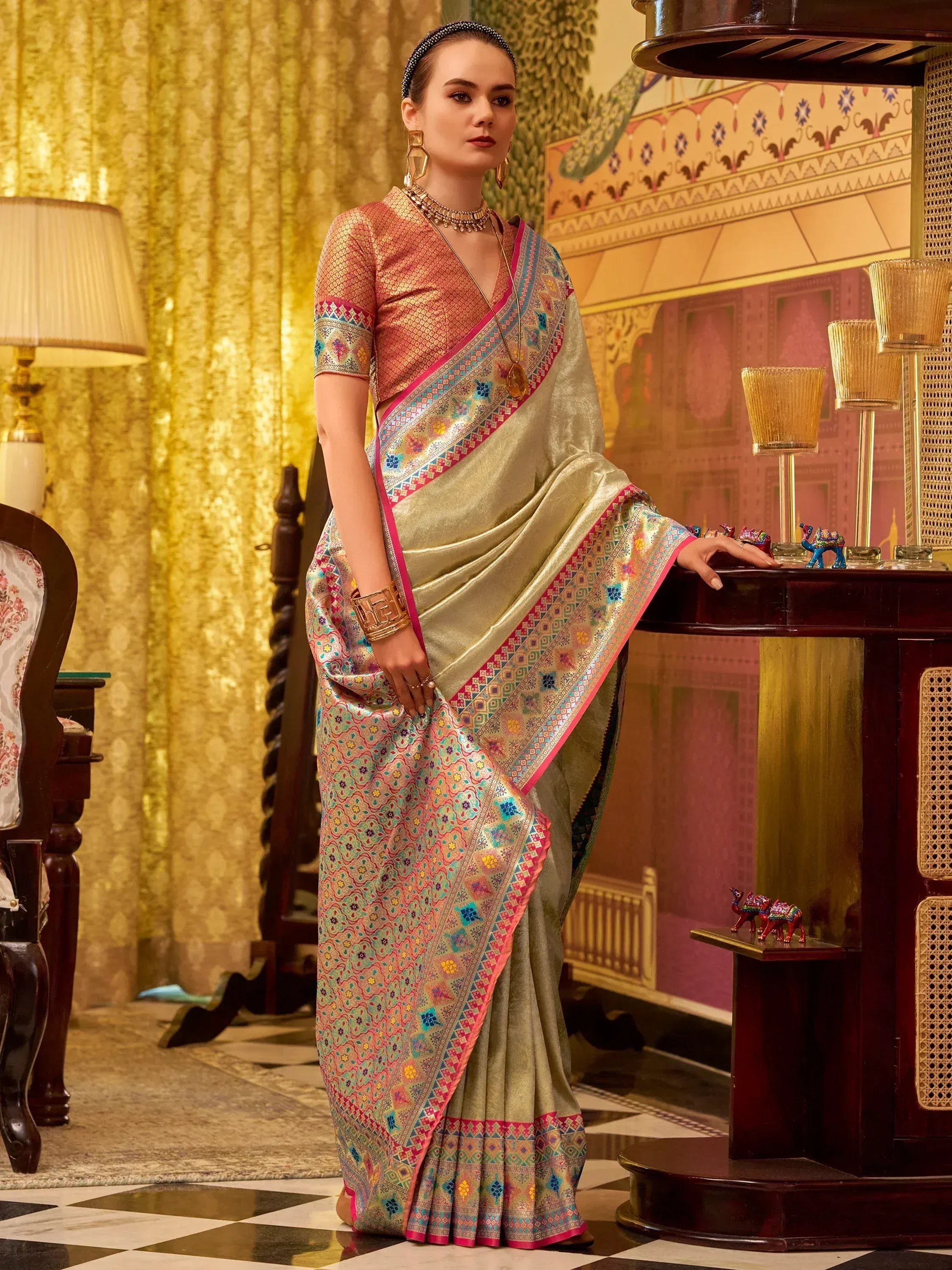 Elegant woman in designer saree with intricate embroidery and vibrant borders, perfect for ethnic occasions.