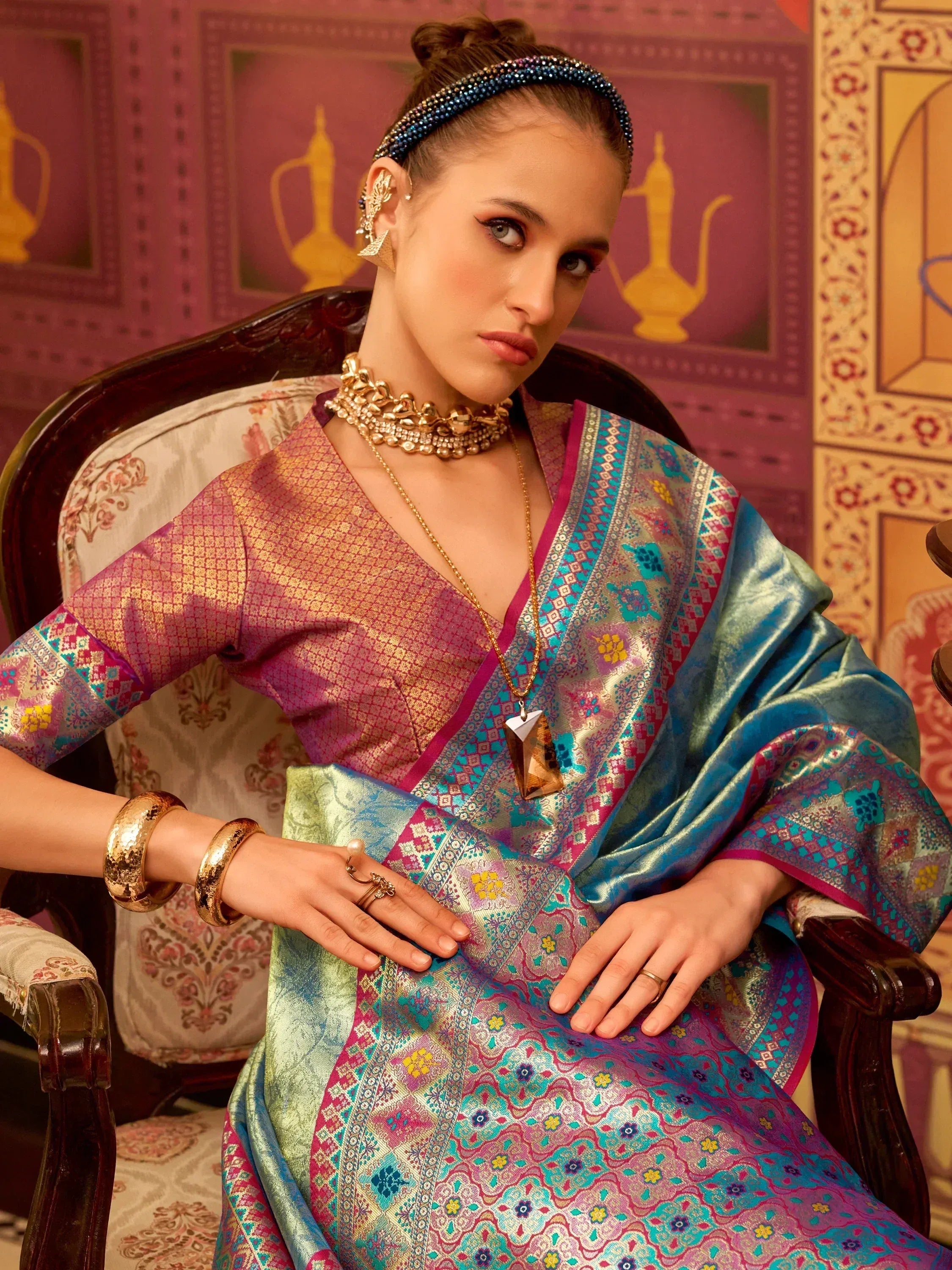 Elegant woman in vibrant Indian ethnic saree with intricate patterns and gold jewelry