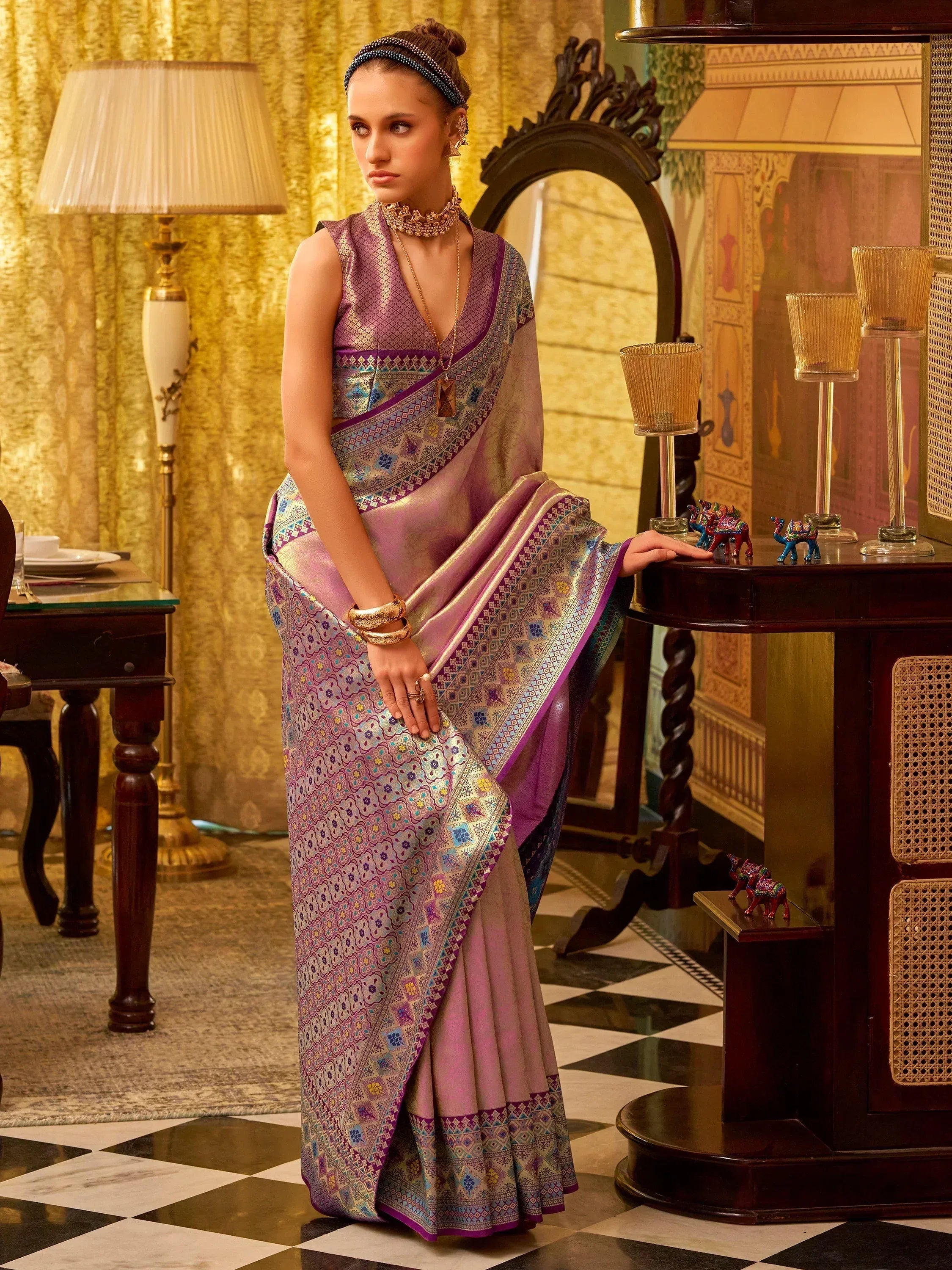 Elegant purple designer saree with intricate embroidery and golden accents, styled for festive occasions.
