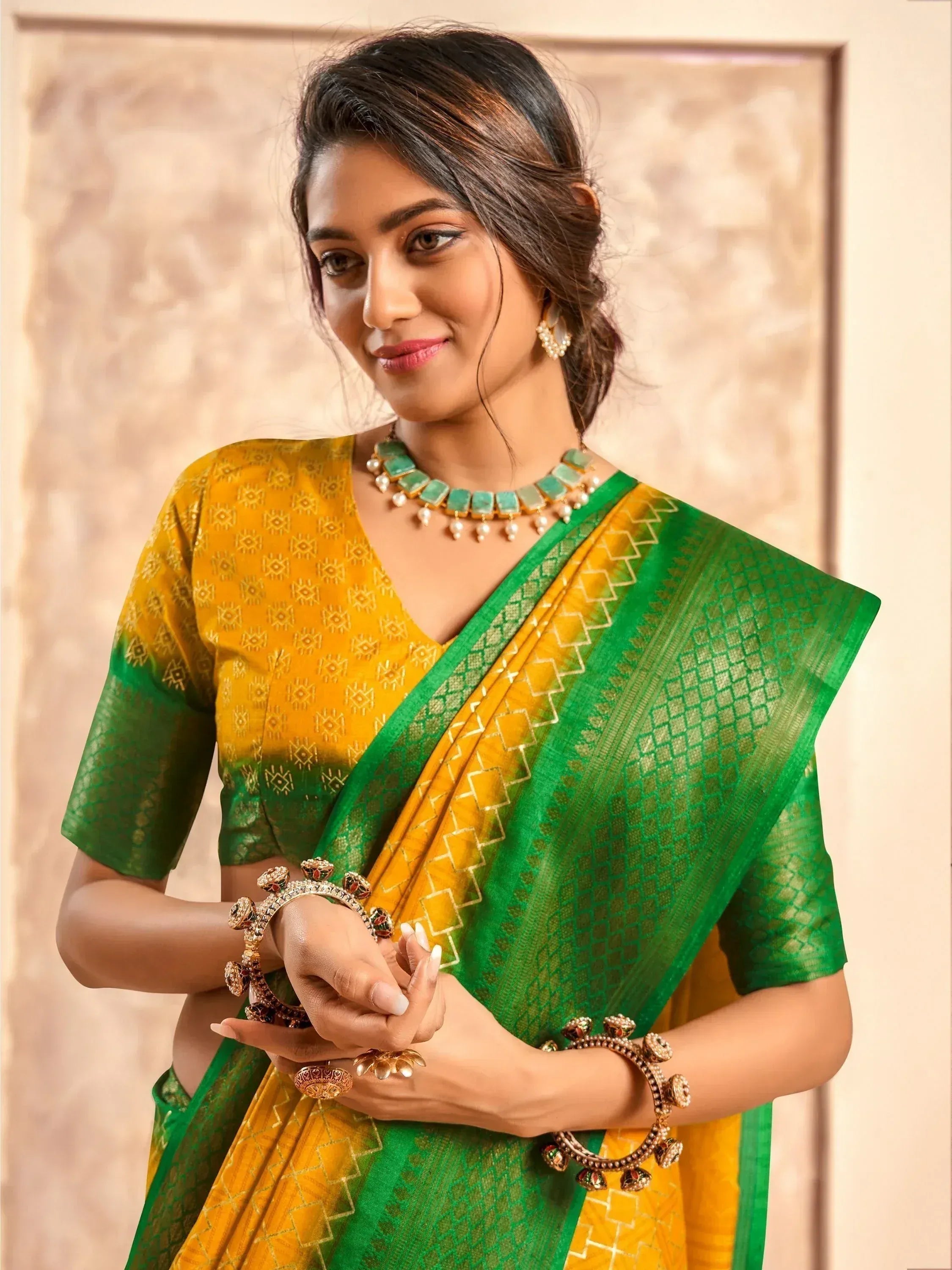 Woman in vibrant green and yellow ethnic saree with gold embroidery, traditional jewelry, perfect for festive occasions