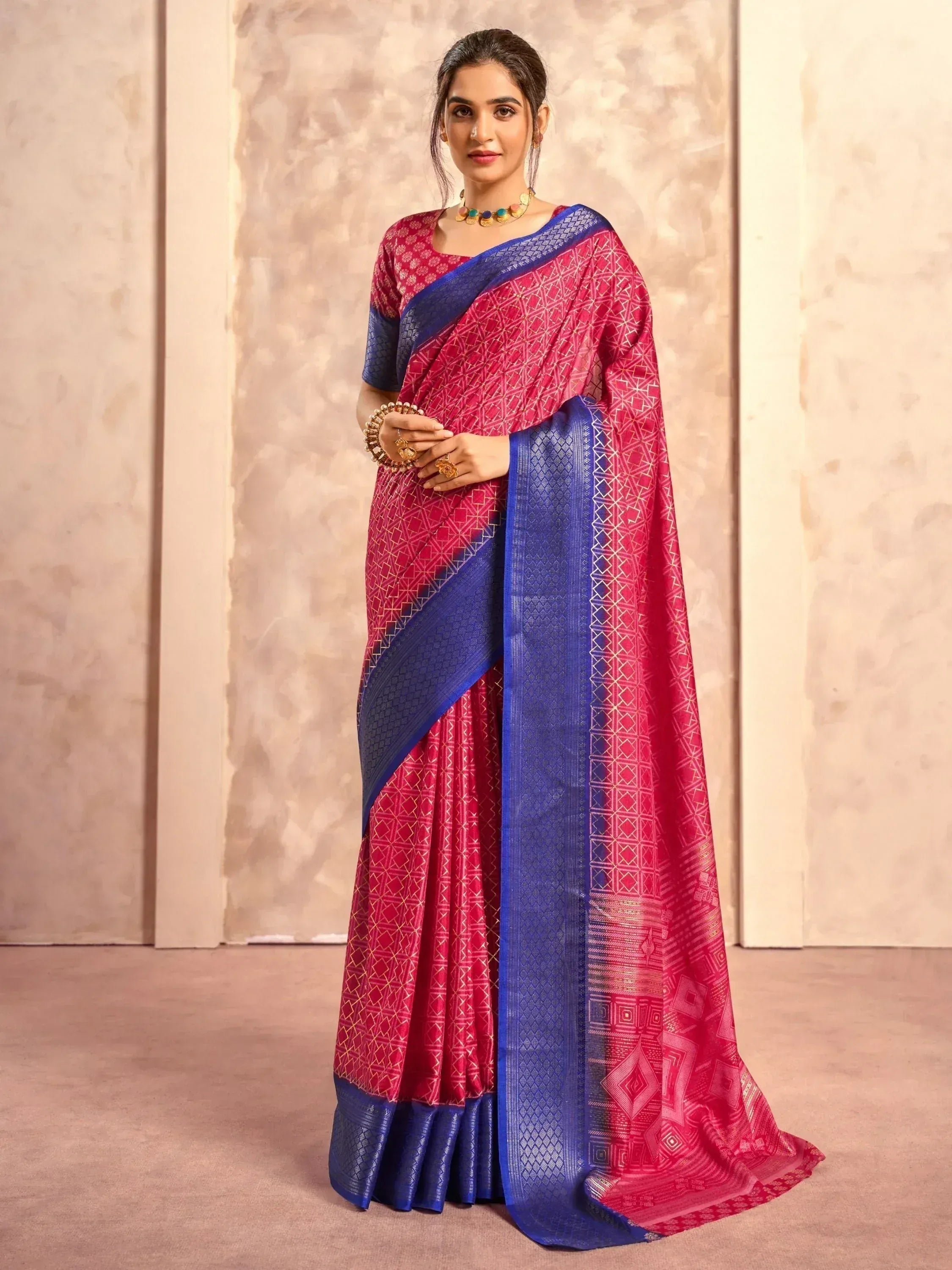 Pink and blue designer saree with geometric print and woven border, styled with gold jewelry for ethnic wear