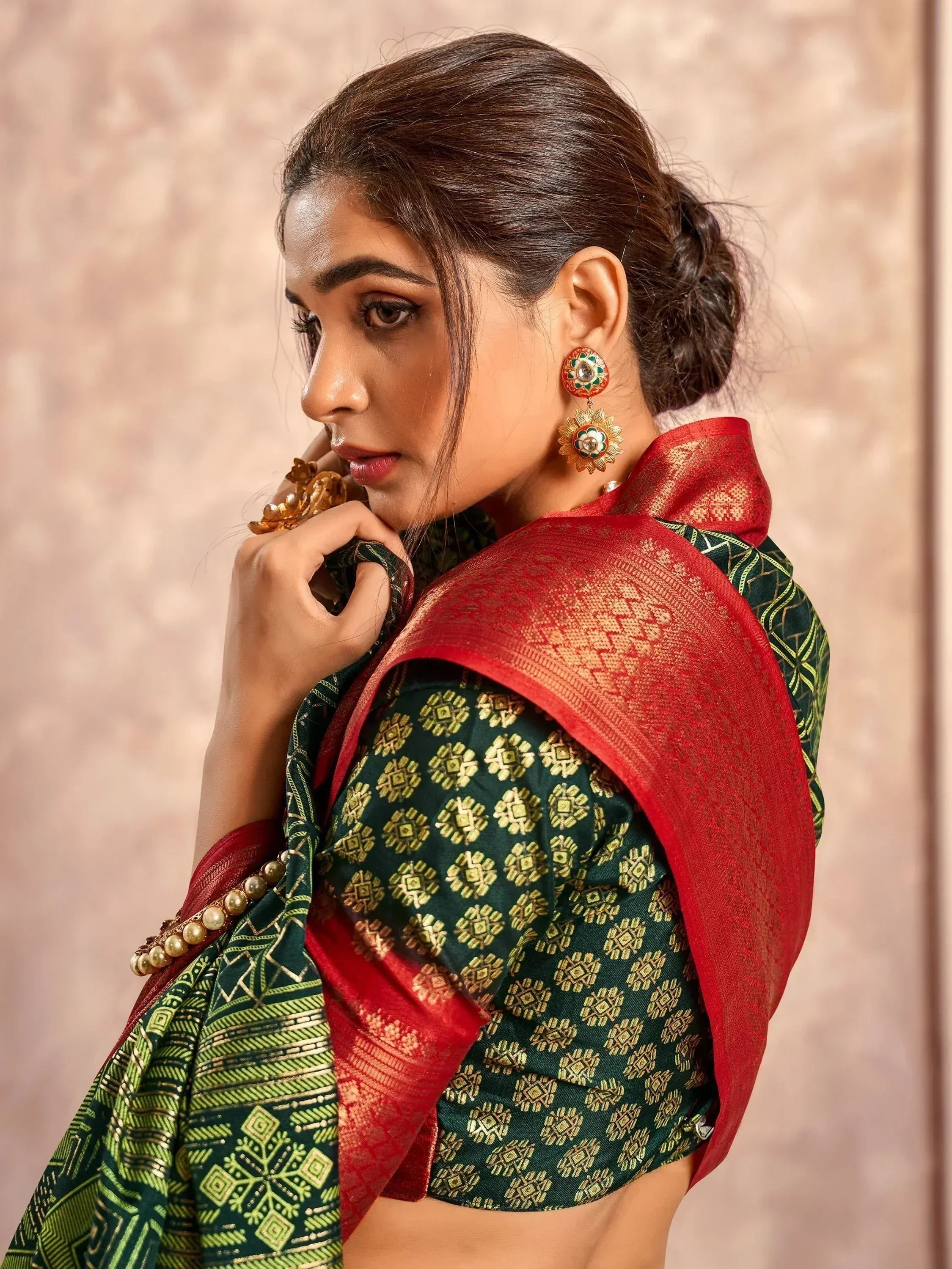 Woman in green and red ethnic saree with gold patterns, traditional Indian wear