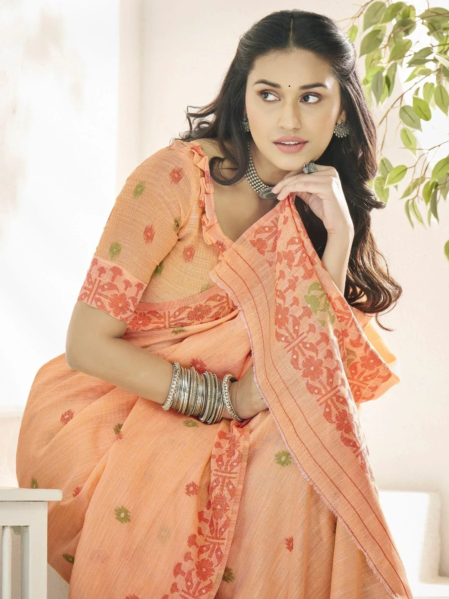 Woman in peach floral saree with ruffled blouse, traditional Indian ethnic wear