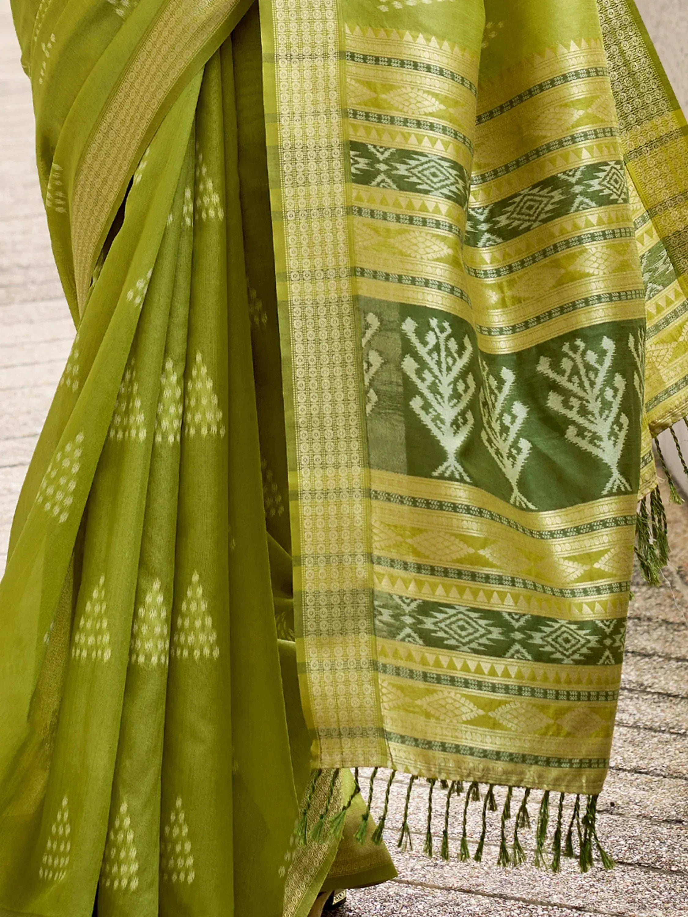 Green ethnic saree with intricate geometric and tree motifs, perfect for traditional occasions.