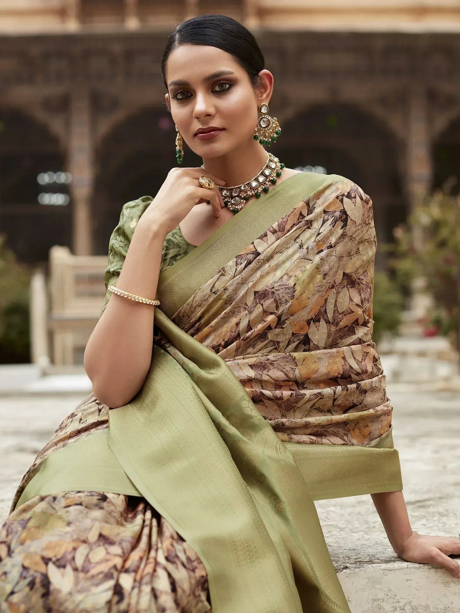 Woman in olive green saree with leaf print, traditional Indian ethnic wear, styled with gold jewelry