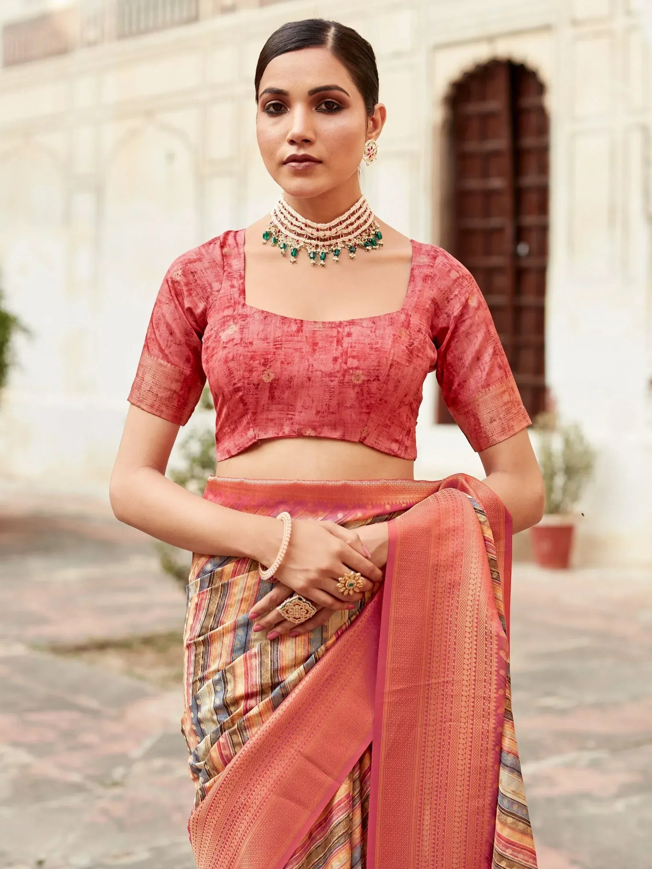 Woman in pink designer saree with matching blouse and traditional jewelry, perfect for ethnic occasions