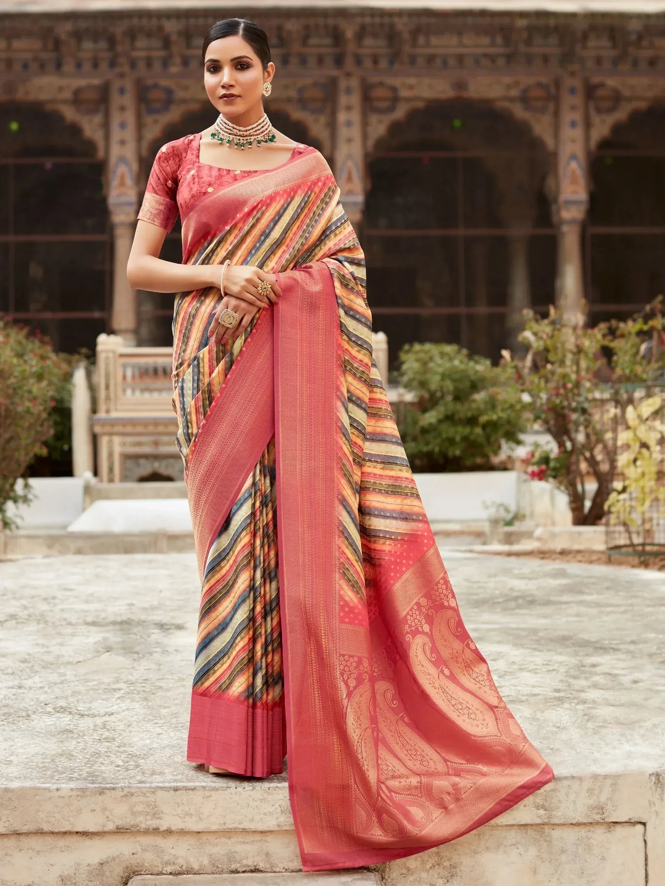 Woman in coral pink ethnic saree with striped and paisley design, traditional Indian wear