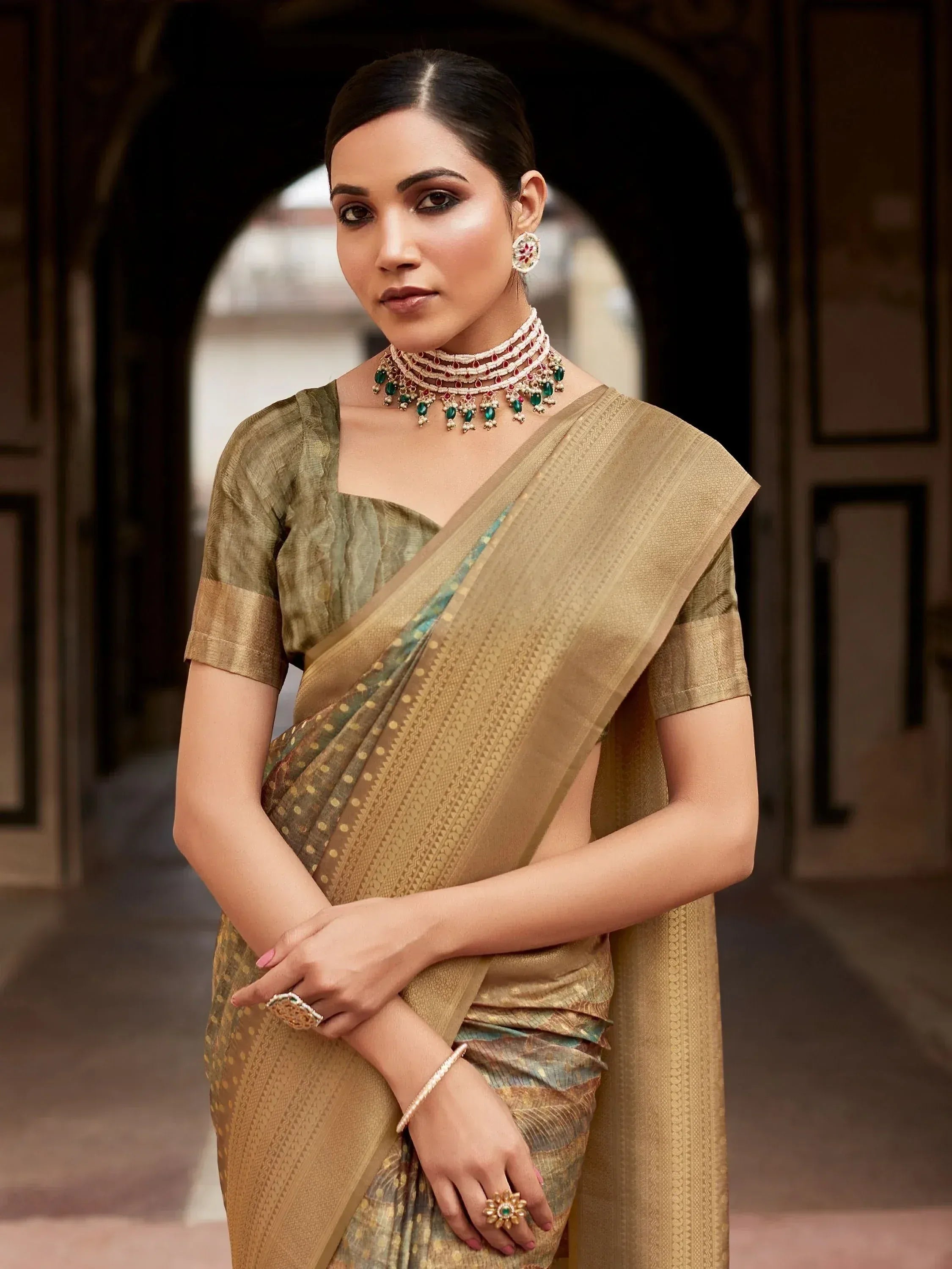 Elegant woman in olive green and gold saree with traditional jewelry, perfect for Indian ethnic wear occasions