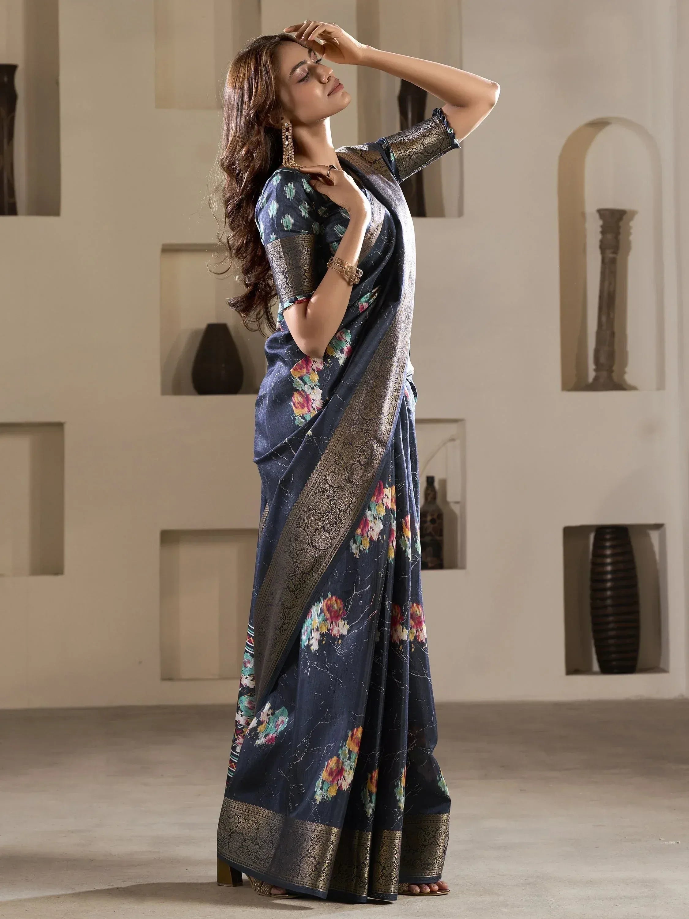 Woman in navy floral saree with gold border, ethnic Indian wear for festive occasions