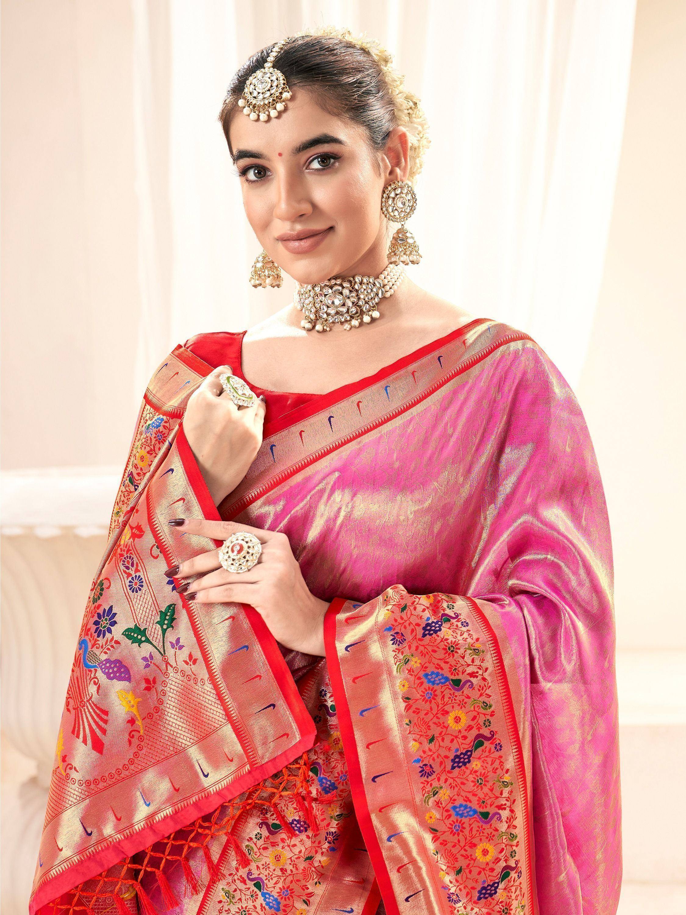 Woman in vibrant pink and red embroidered saree with traditional jewelry, perfect for Indian ethnic wear occasions.